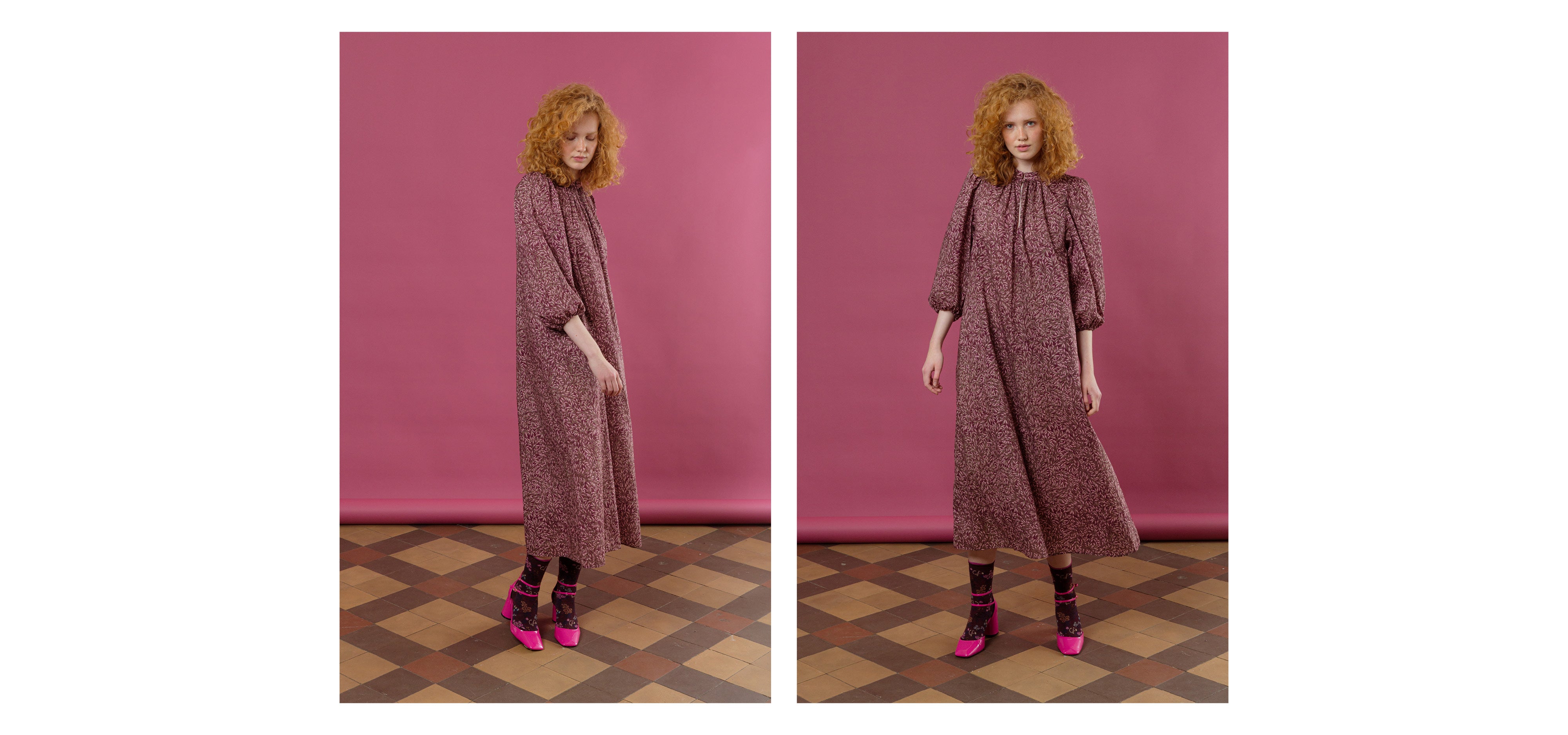 Woman in purple patterned dress with long puffed sleeves