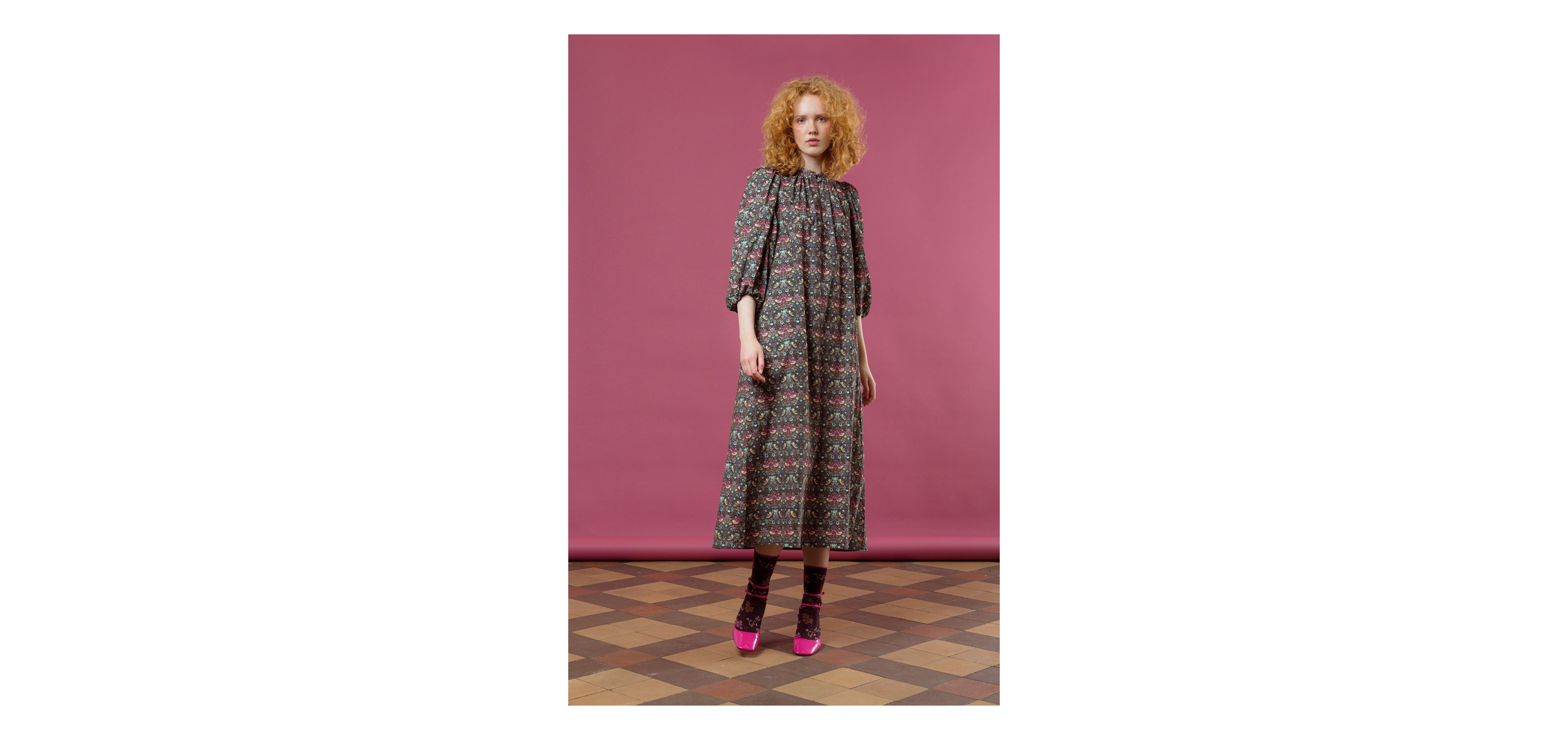 Woman in midi dress with green and red floral pattern and long puffed sleeves