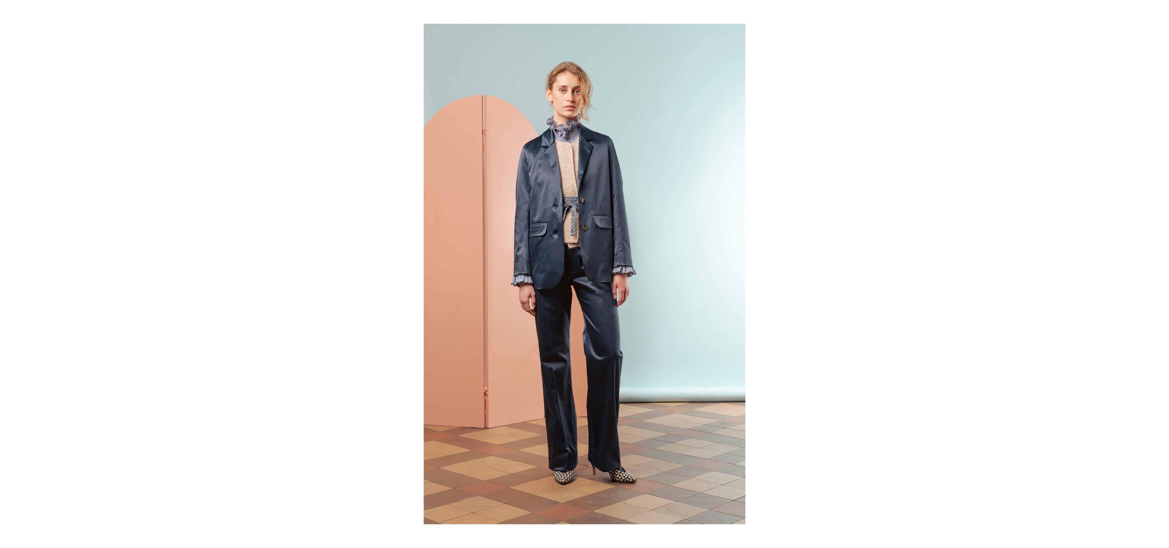 Woman in blue shiny costume, blue and white striped shirt with frilled collar and beige vest