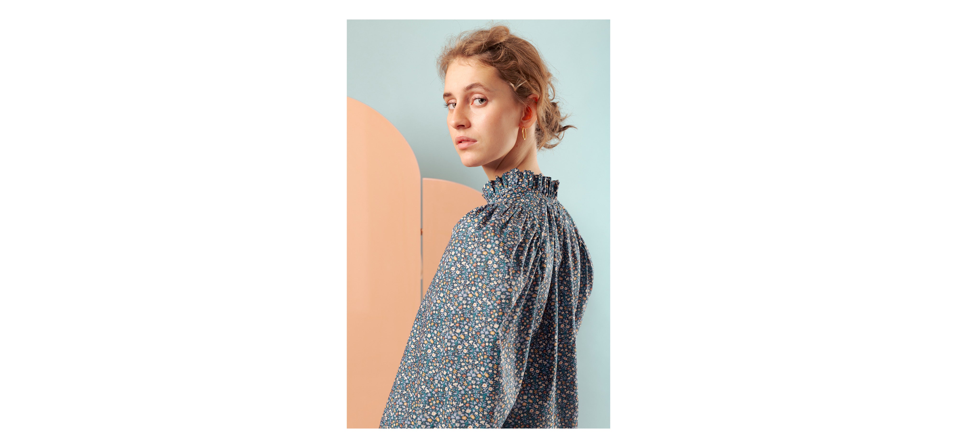 Woman in long sleeve floral print Liberty cotton shirt with frilled collar