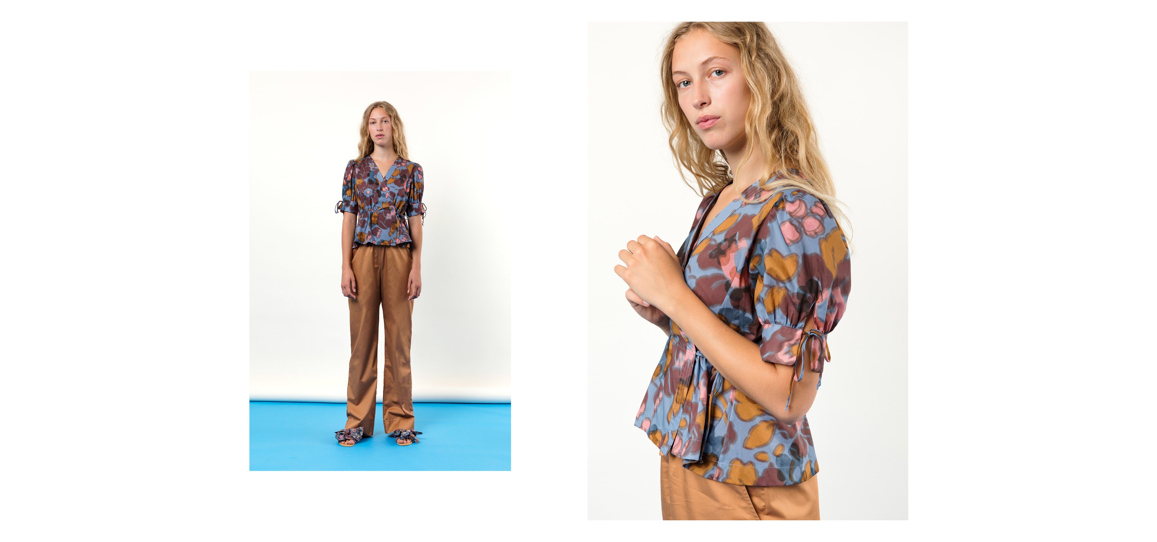 Woman in brown trousers and short sleeved wrap shirt with blue brown and pink floral print