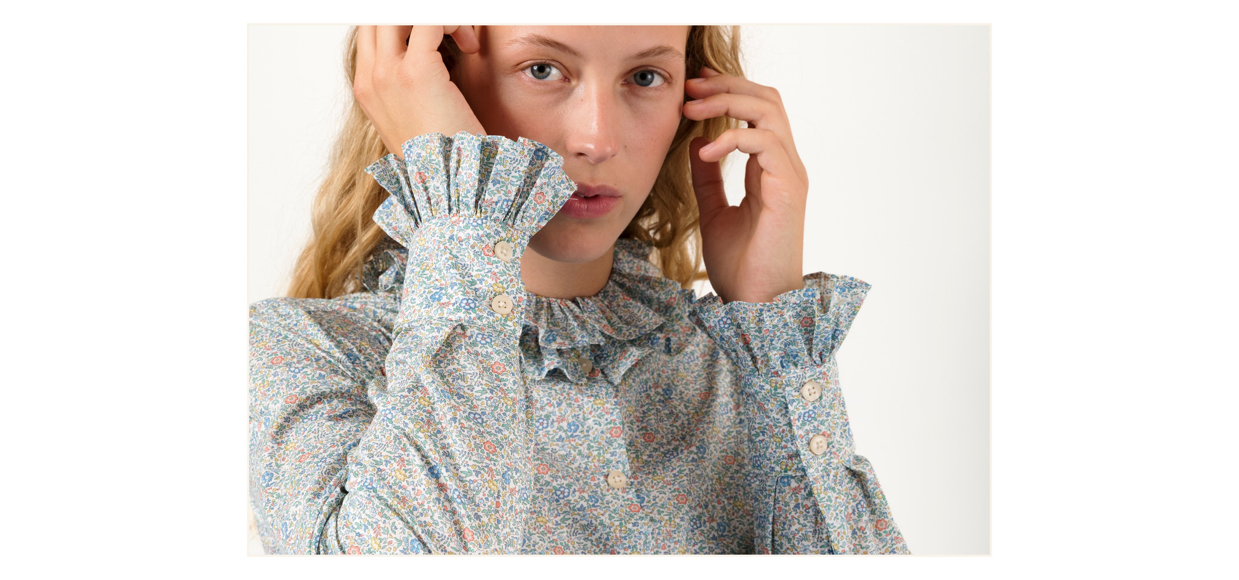 Woman in multi-colored long sleeved Liberty cotton floral print shirt with ruffles