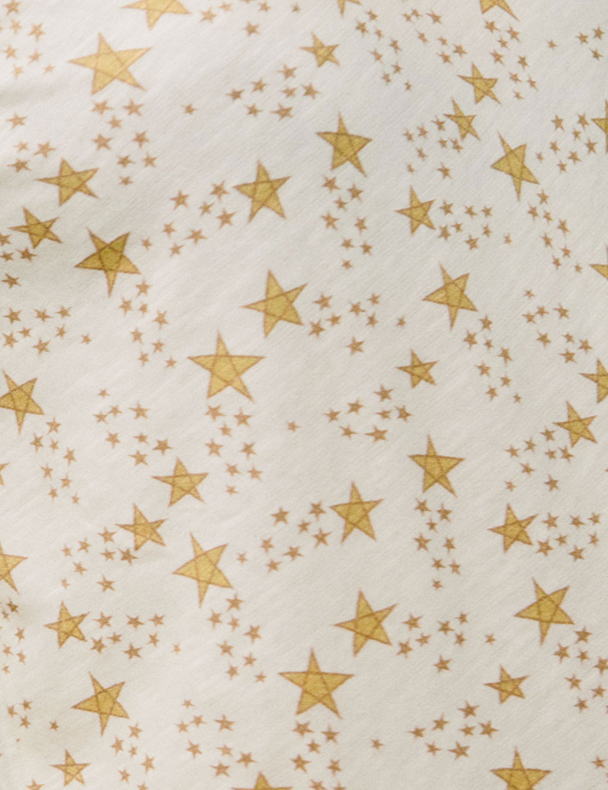 Close-up of cream cotton fabric with gold star pattern
