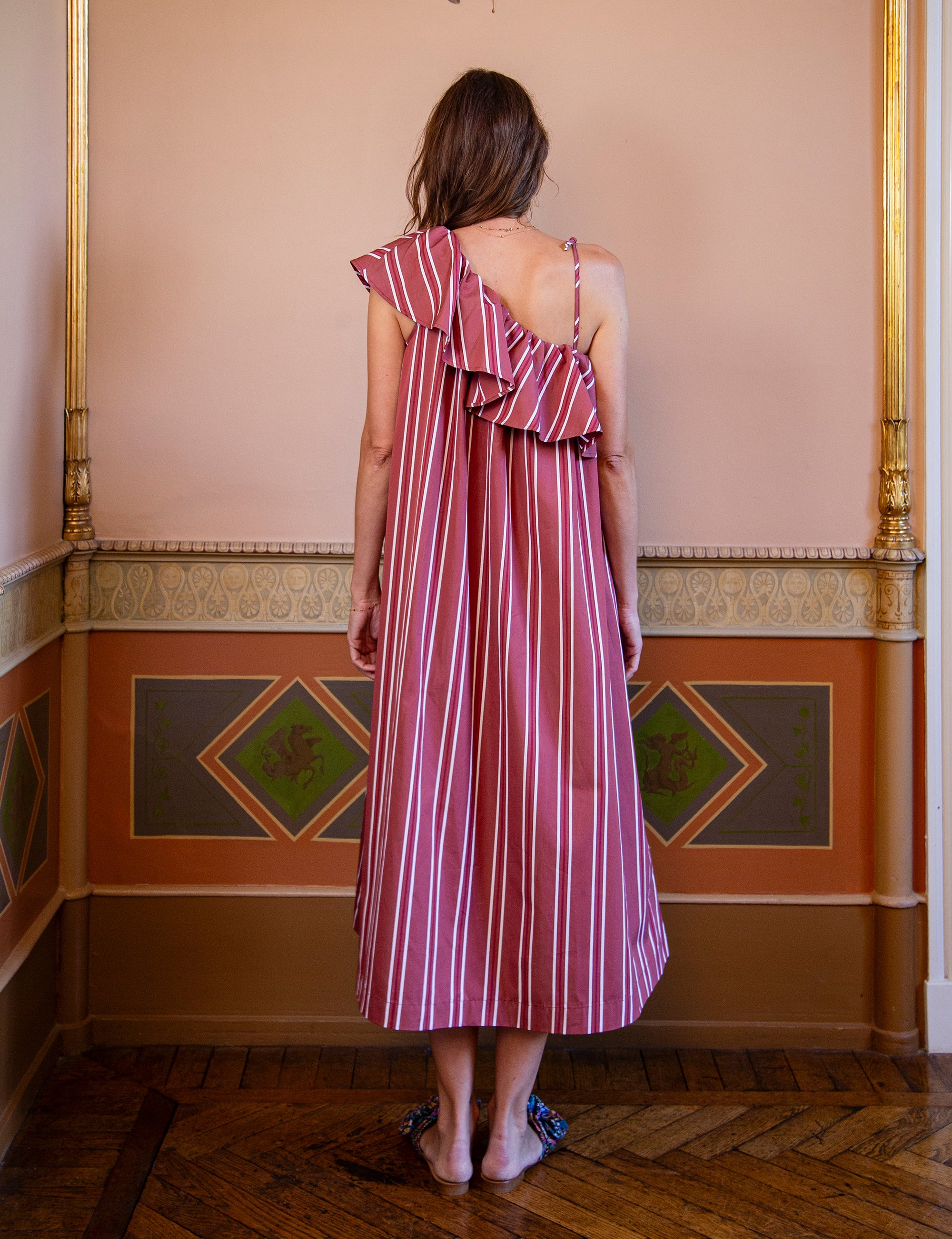 Woman wearing a red and white striped one shoulder dress