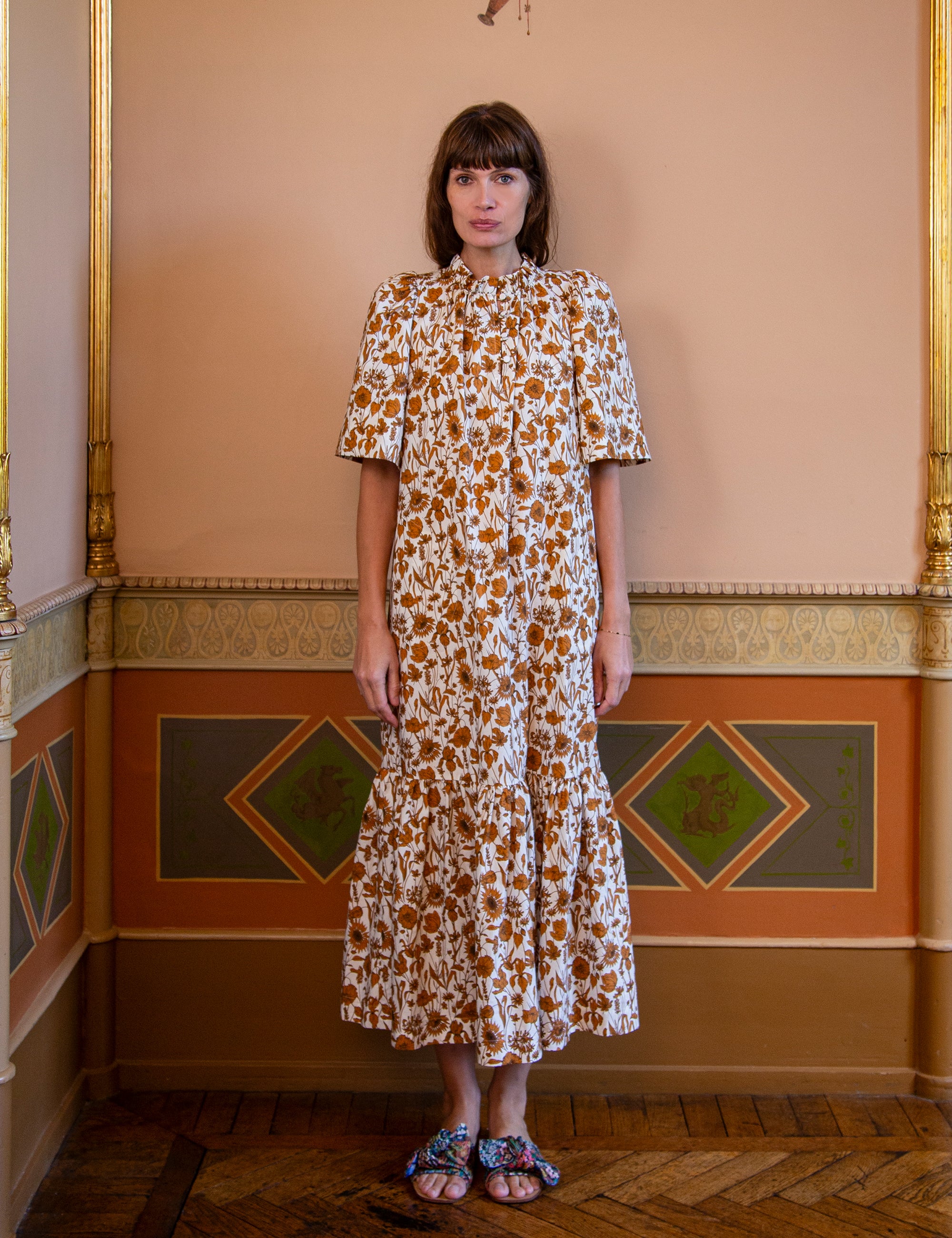 Woman wearing a white and brown floral summer dress with short puff sleeves