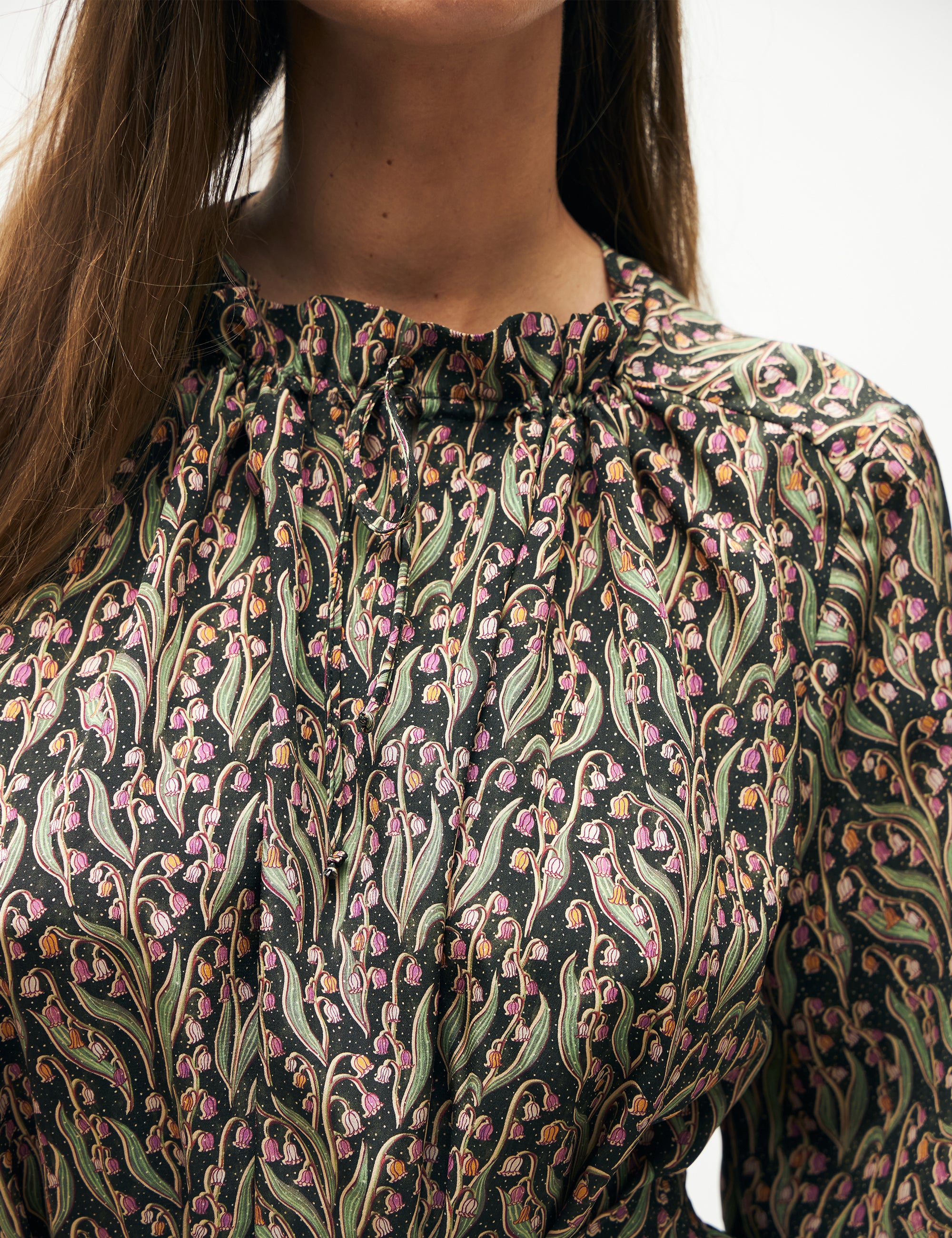 Woman in long sleeved dress with pink and green flower pattern