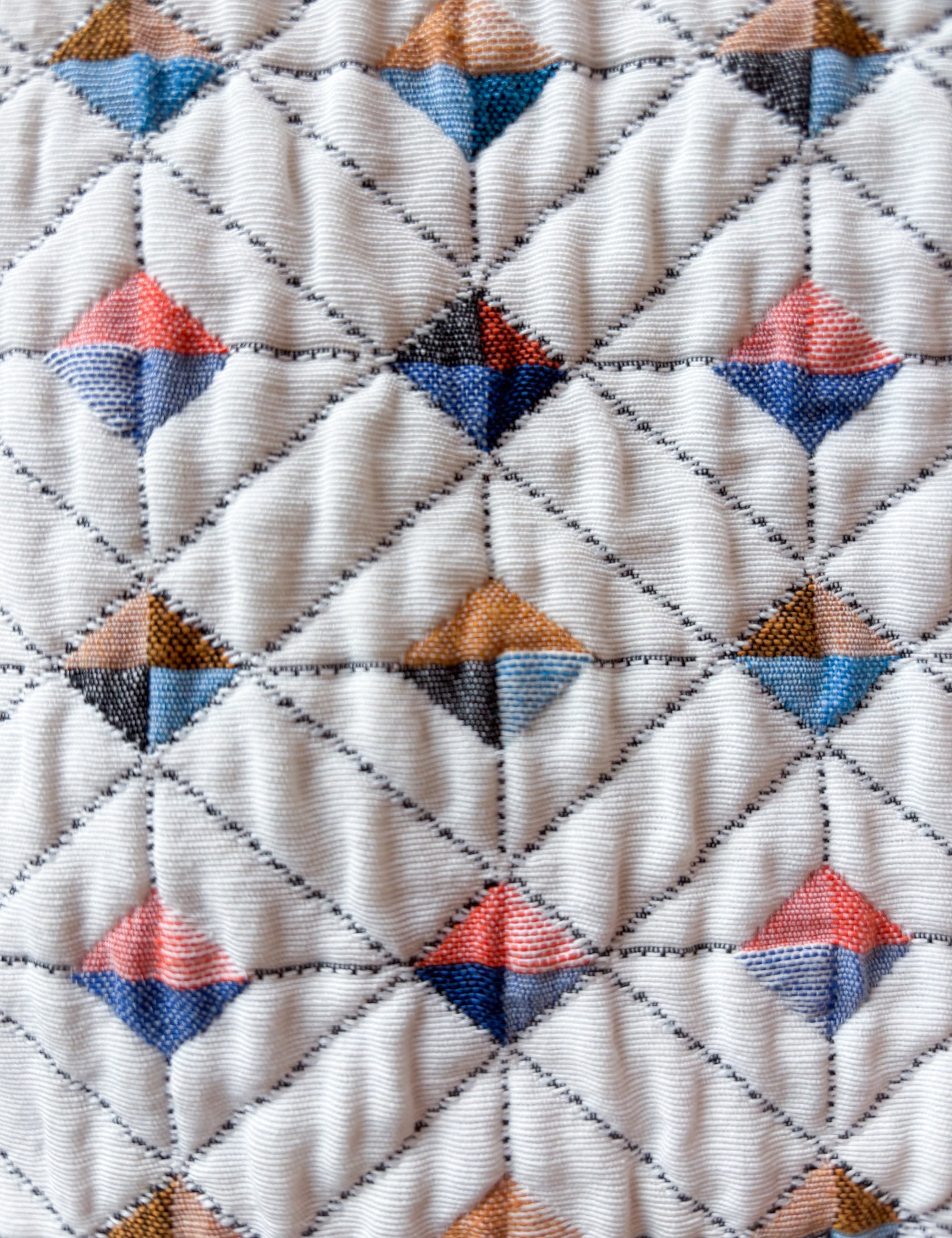 Close-up of white quilted fabric with multi-colored check pattern for Women's jacket
