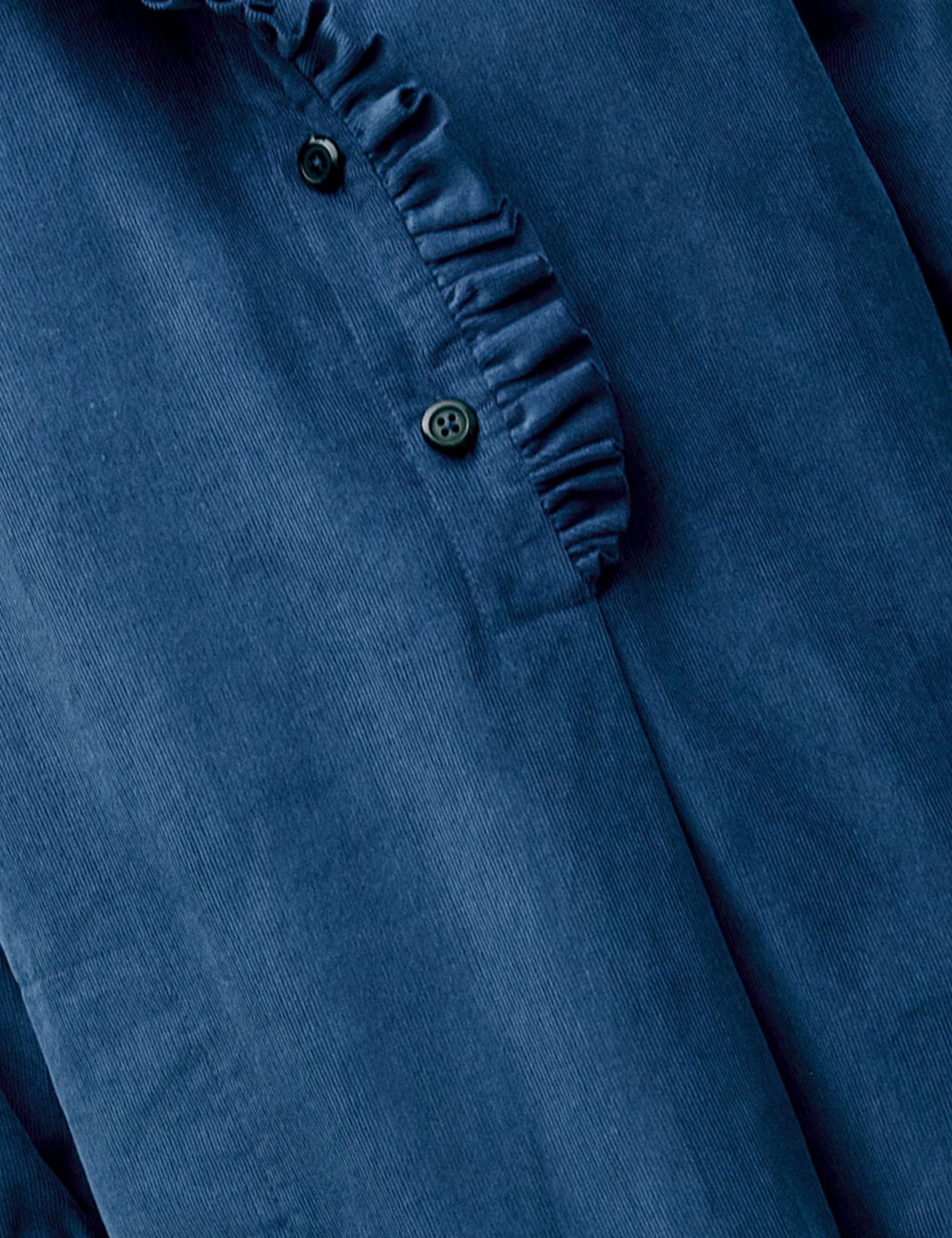 Close-up of ruffle collar and buttons on corduroy shirt dress
