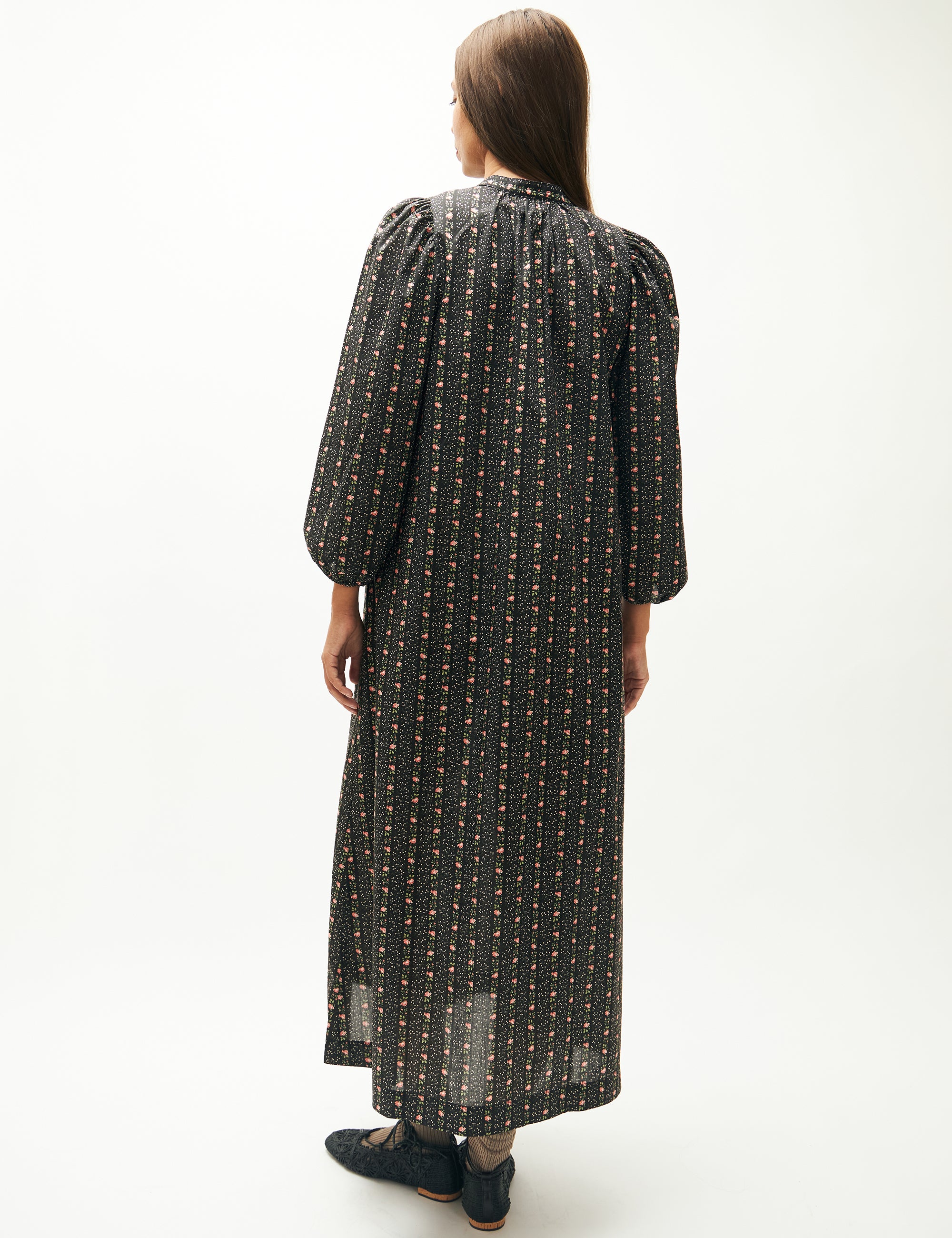 Woman in long dress with floral striped pattern, long puff sleeves