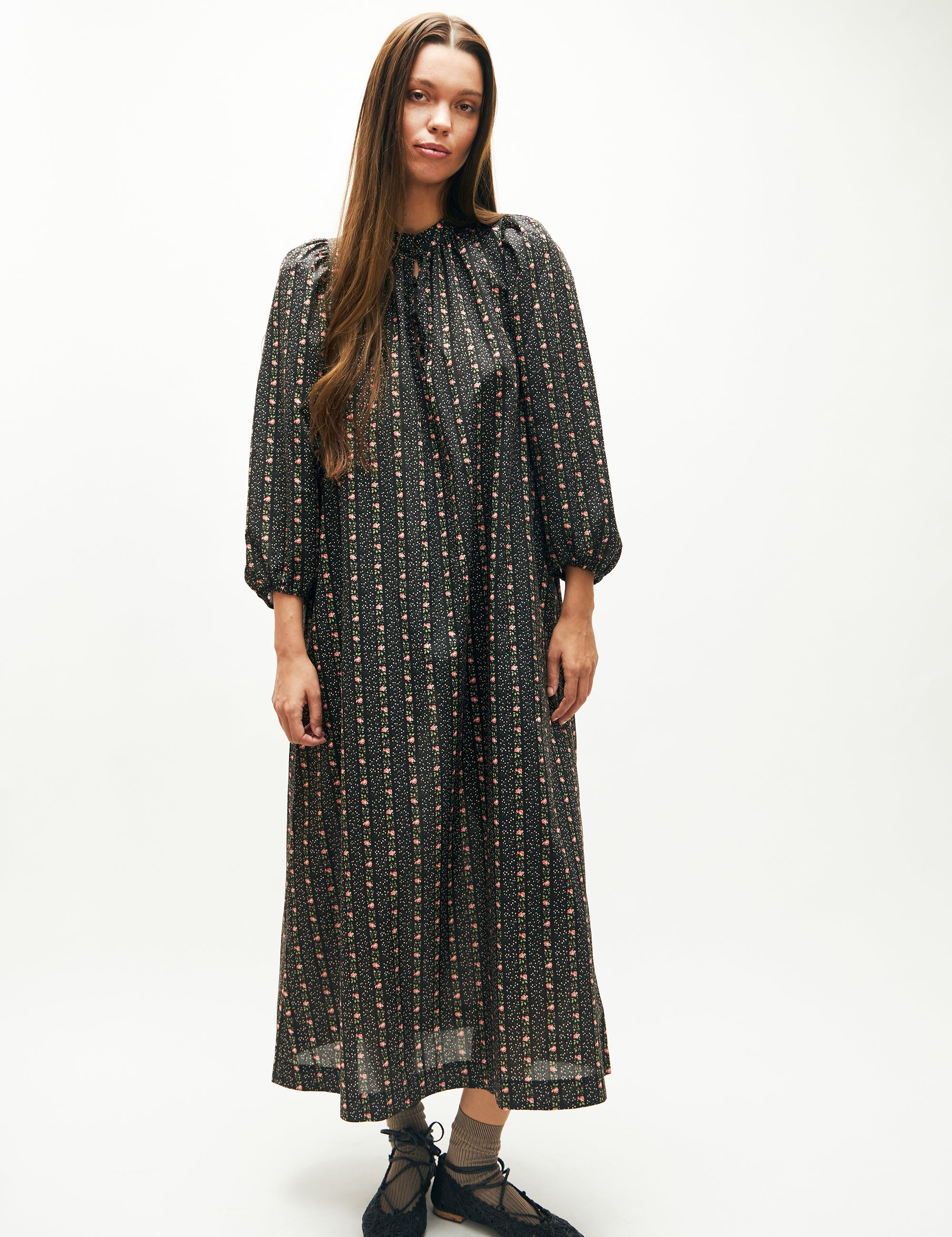 Woman in long dress with floral striped pattern, long puff sleeves