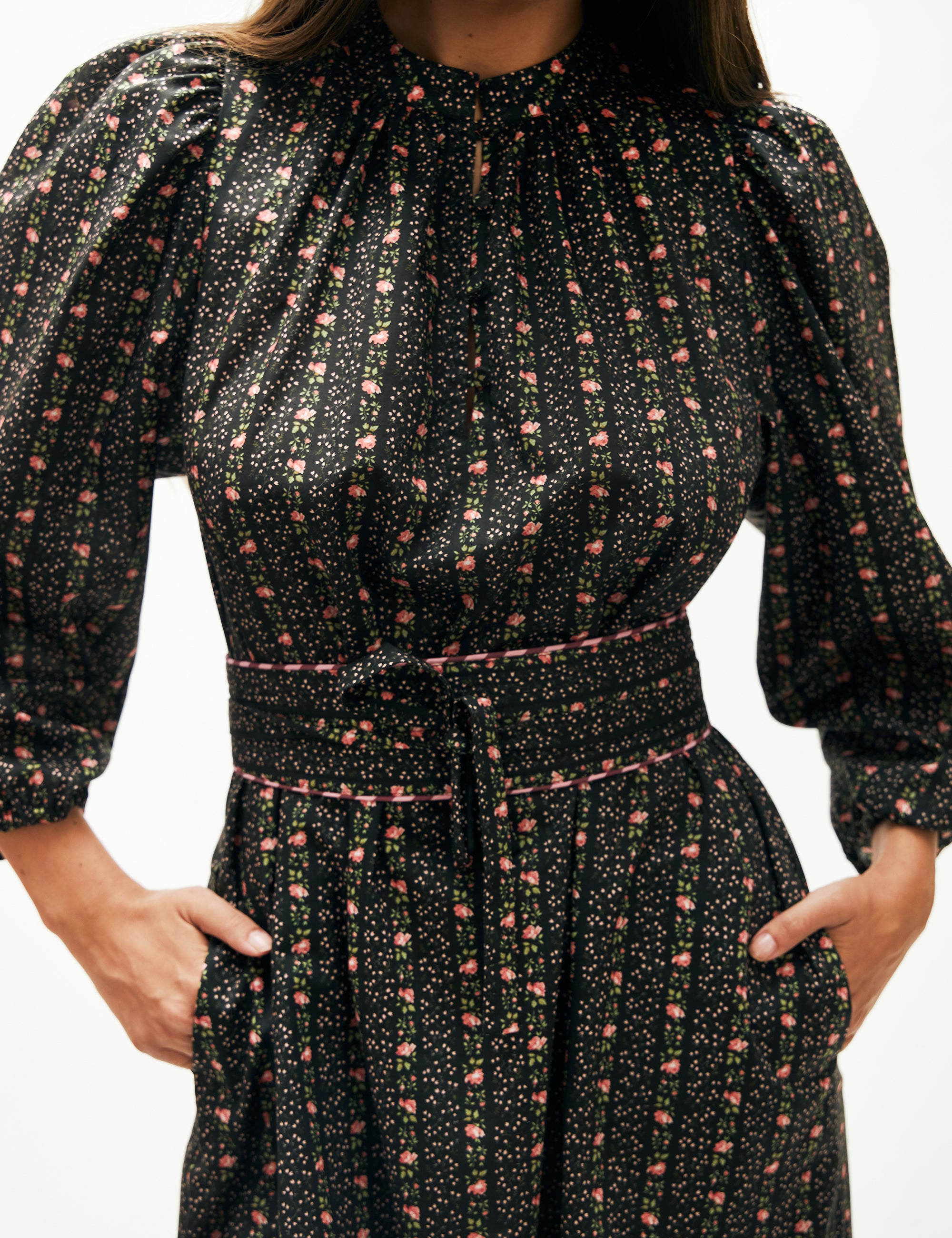 Woman in long dress with floral striped pattern, long puff sleeves and matching fabric belt