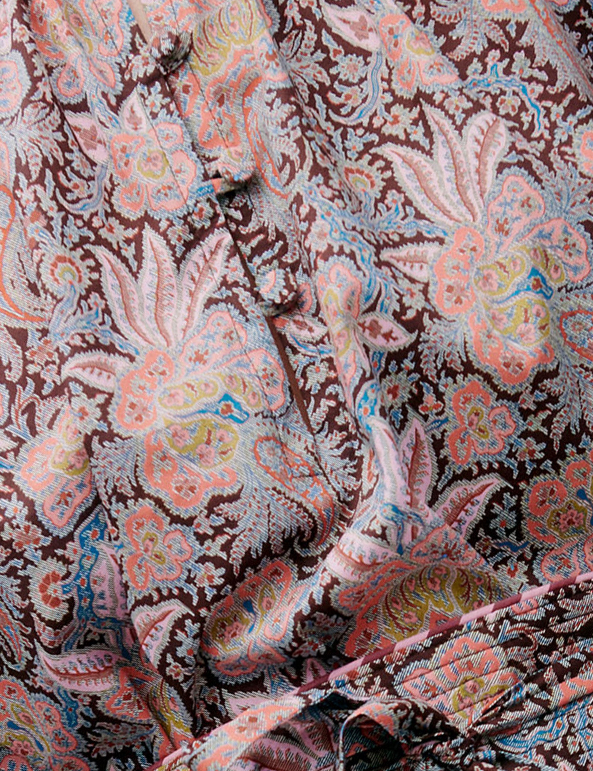 Detailed close-up of pink dress fabric with paisley and floral print