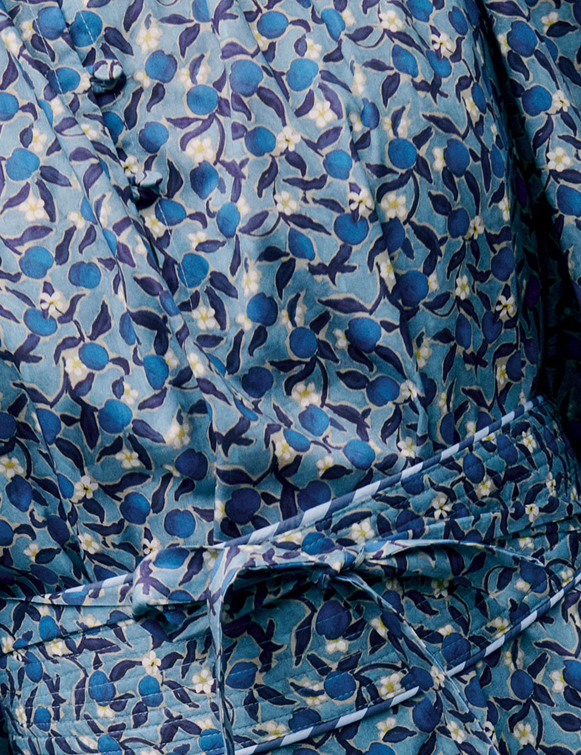 Detailed close-up of blue floral fabric with small leaf pattern