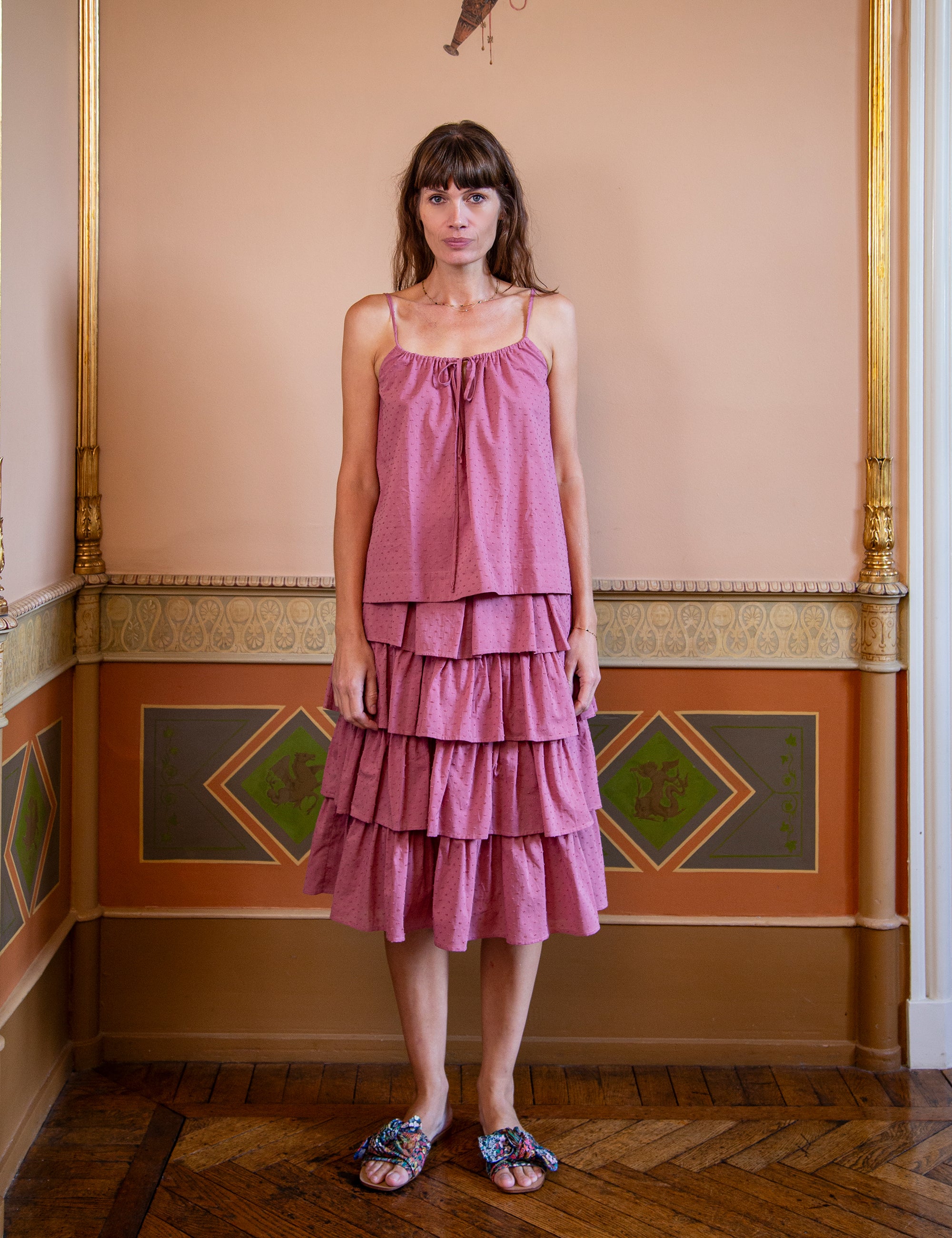 Woman wearing a pink strap top and a matching pink tiered skirt