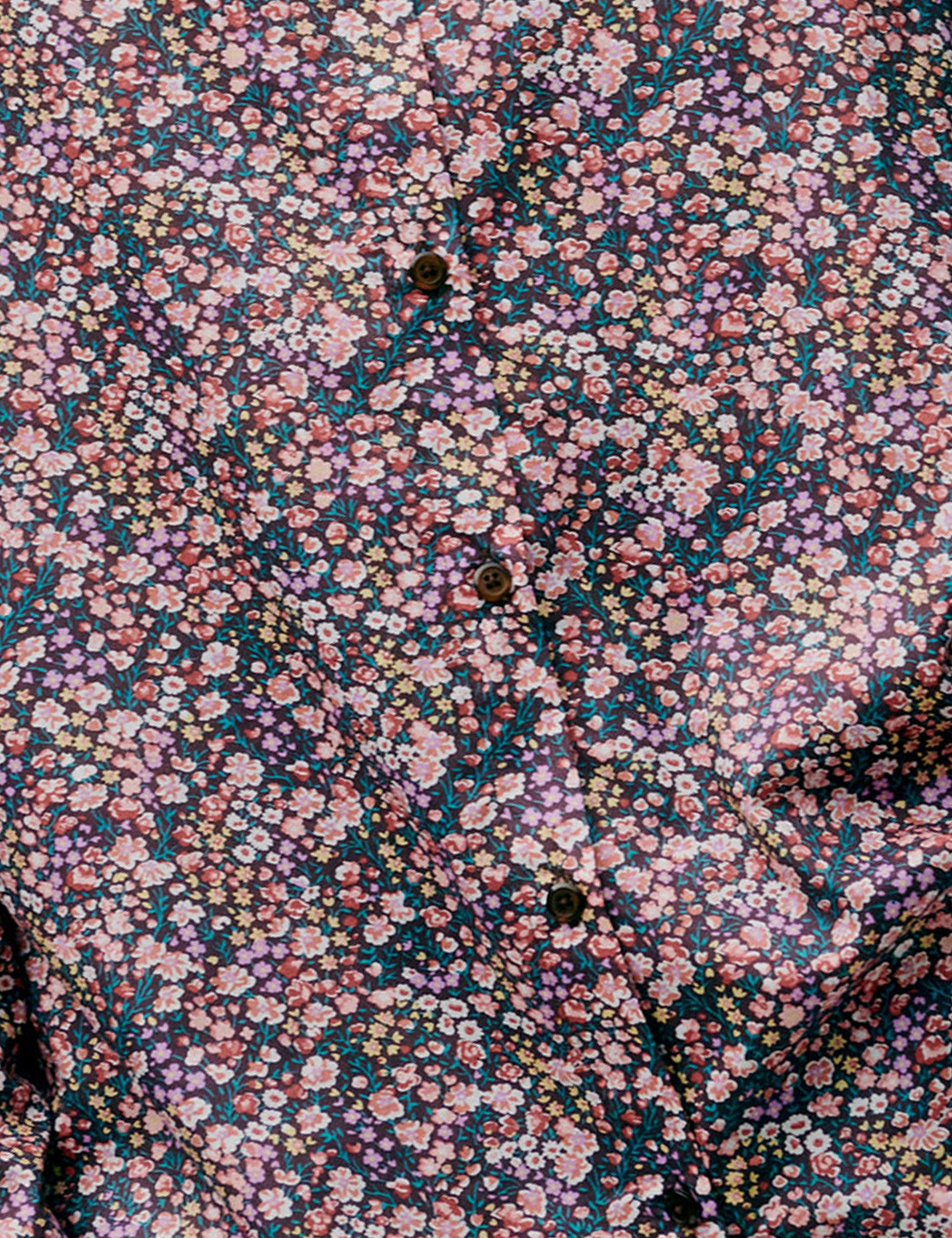 Close-up of a floral patterned fabric with small pink and purple flowers.