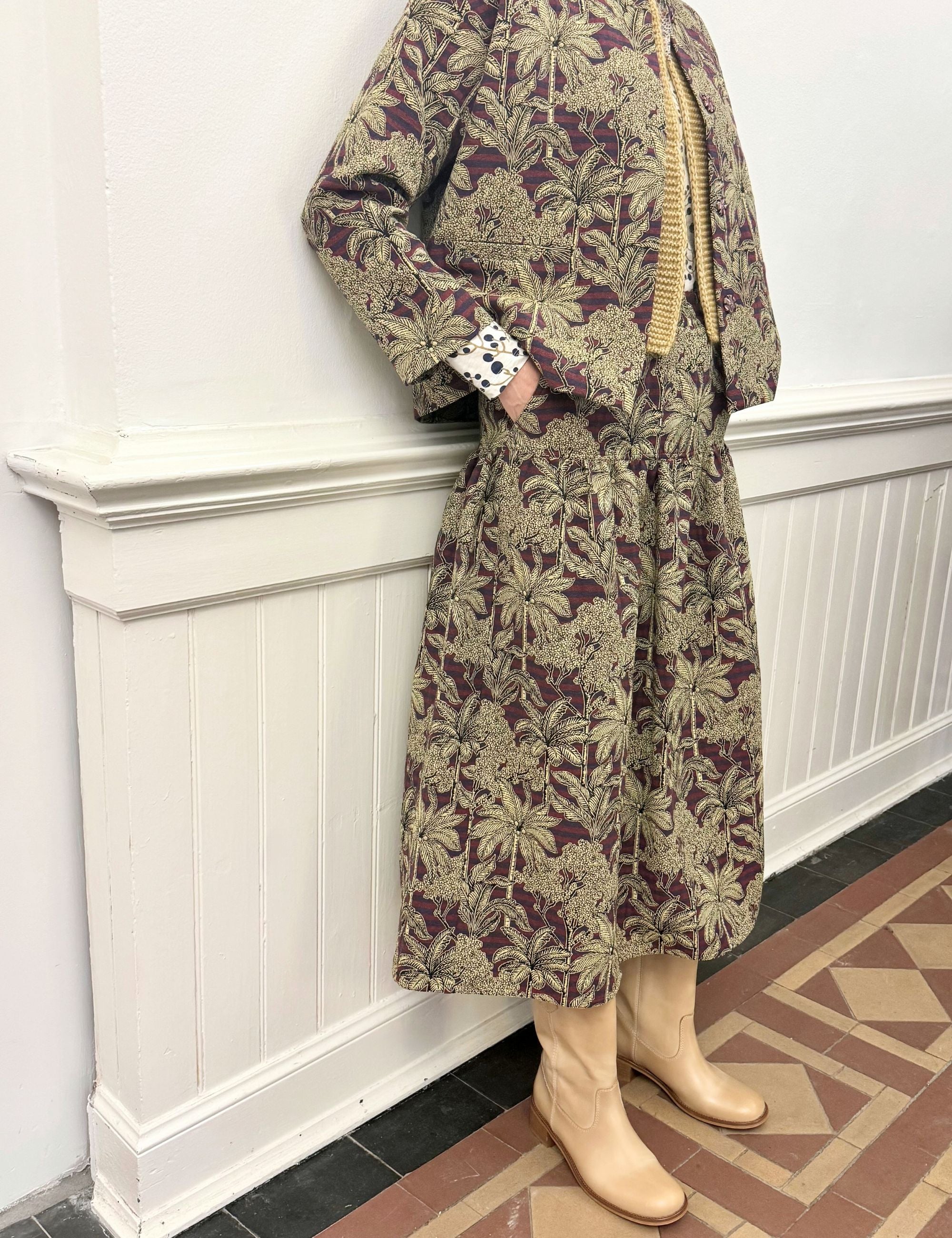 Woman in palm print jacket and skirt