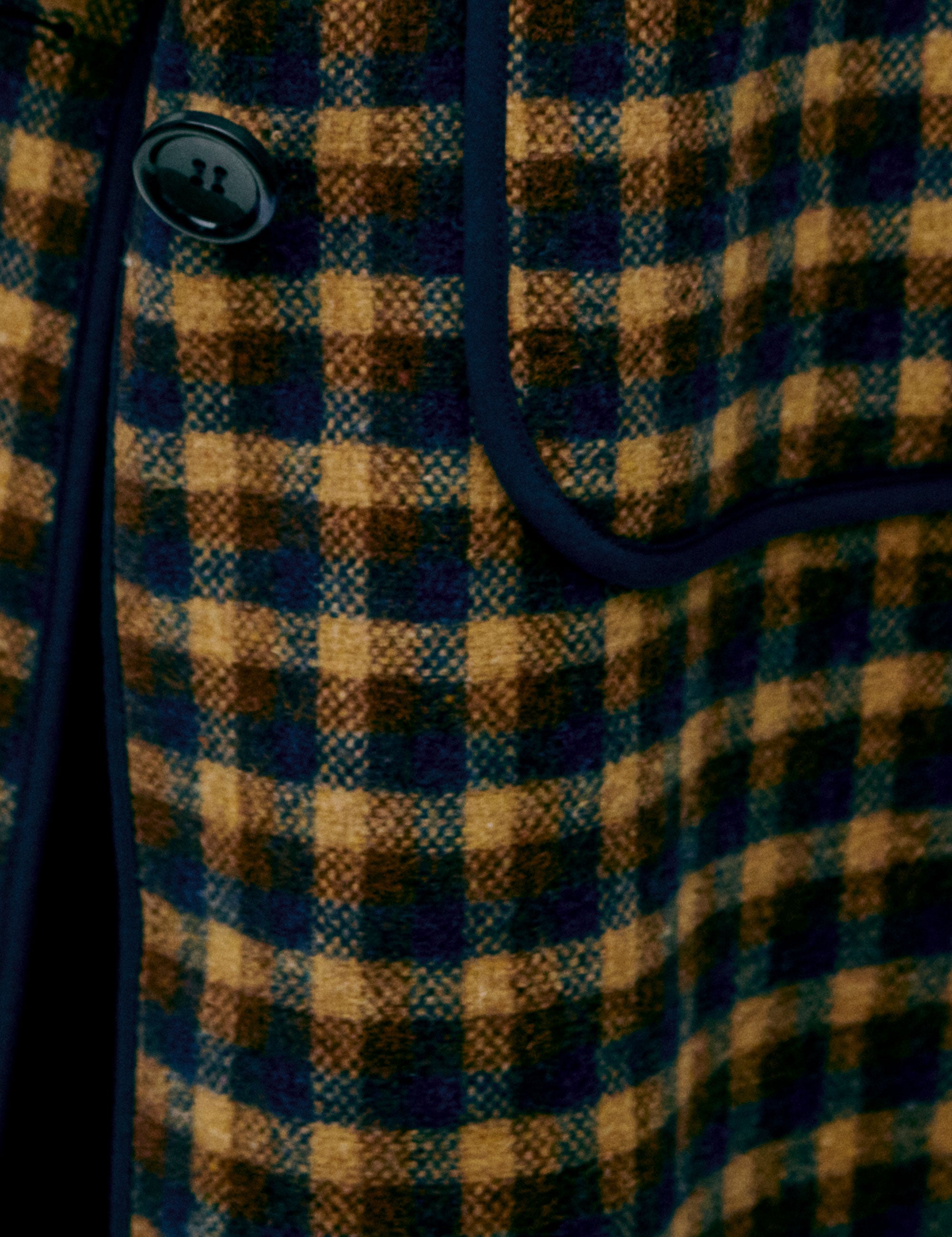 Close-up of a checkered women's vest with blue and yellow pattern