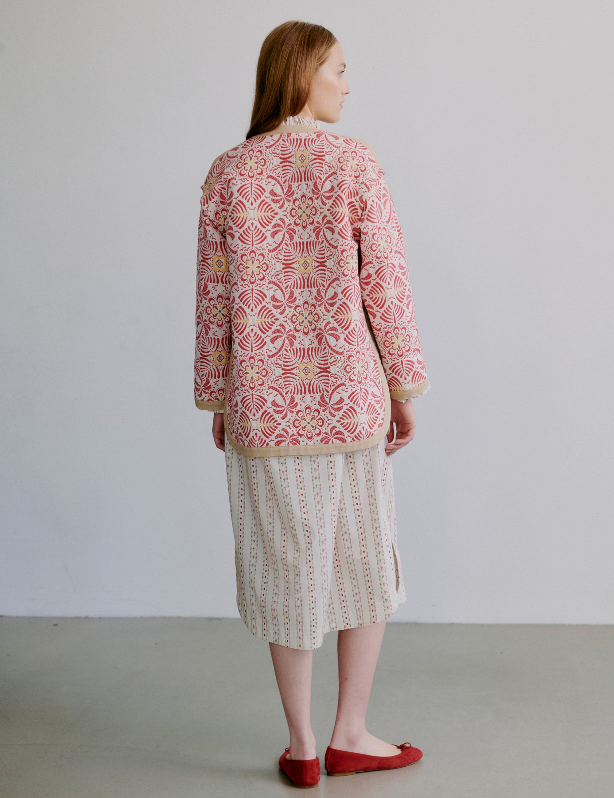 Kvinna i ljus mönstrad klänning med långa ärmar och volanger