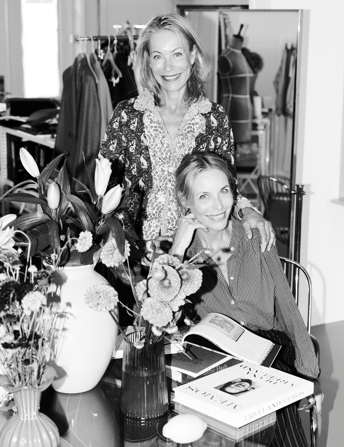APOF founders Kathrine and Frederikke Hviid in the studio, photographed in black and white among flowers, books and clothing.