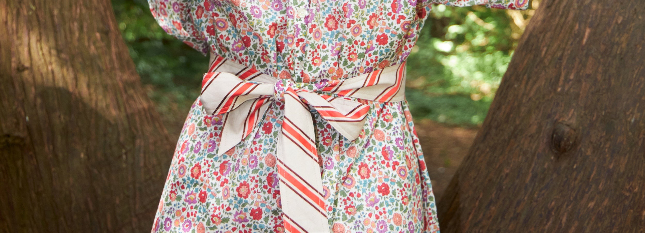Woman in romantic flower patterned dress and red and white striped cotton belt