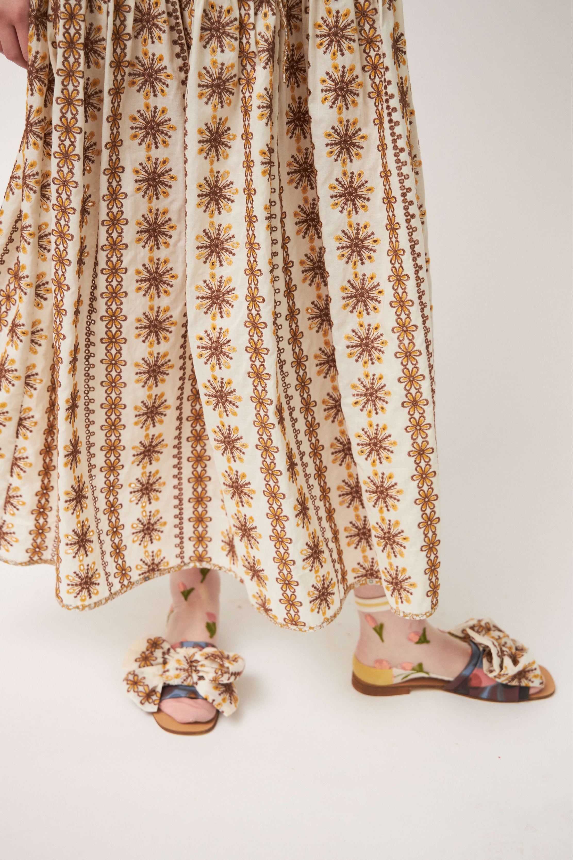 Maxi skirt with laced beige and white pattern and sandals with bow
