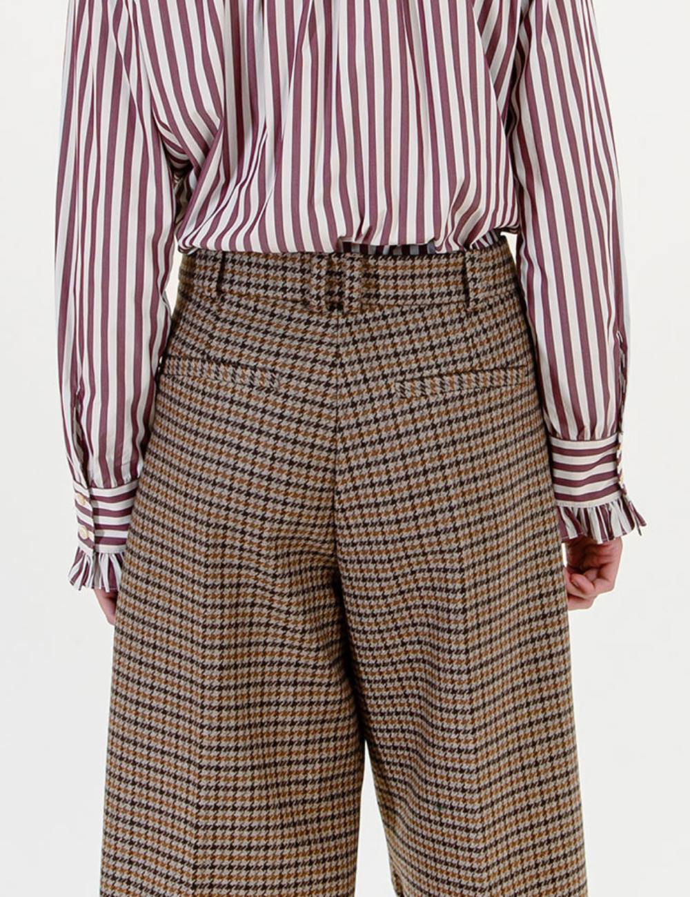 Woman in brown checkered pants and striped shirt