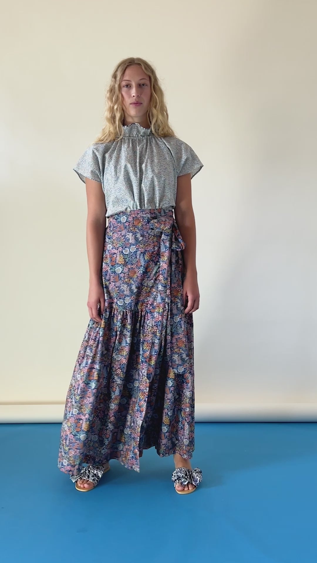 Woman in green blouse and flower patterned skirt