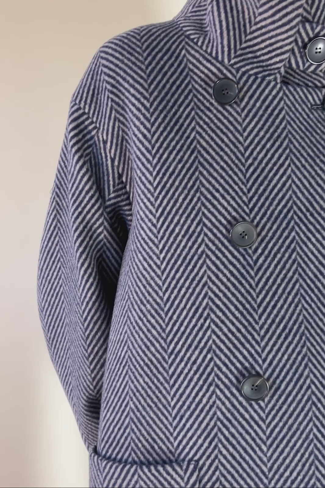 Woman in navy blue herringbone patterned wool jacker with buttons