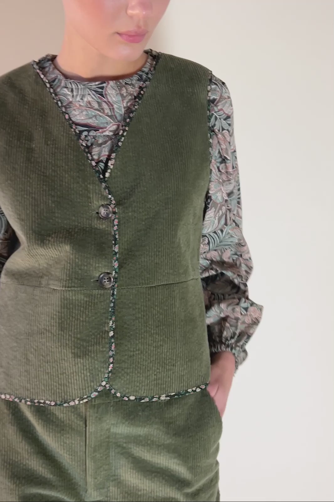 Woman in green corduroy pants and vest and green paisley print Liberty cotton shirt