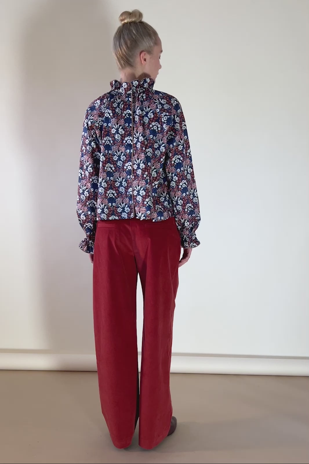 Woman in red baby cord pants and Liberty cotton floral print shirt Primrose in red white and blue