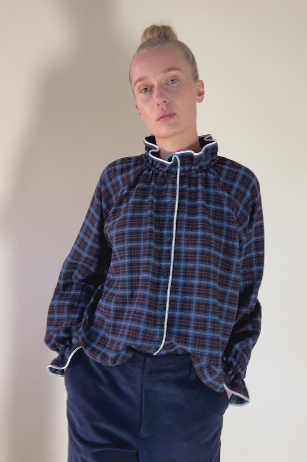 Woman in blue check patterned seersucker shirt with frilled collar and cuffs