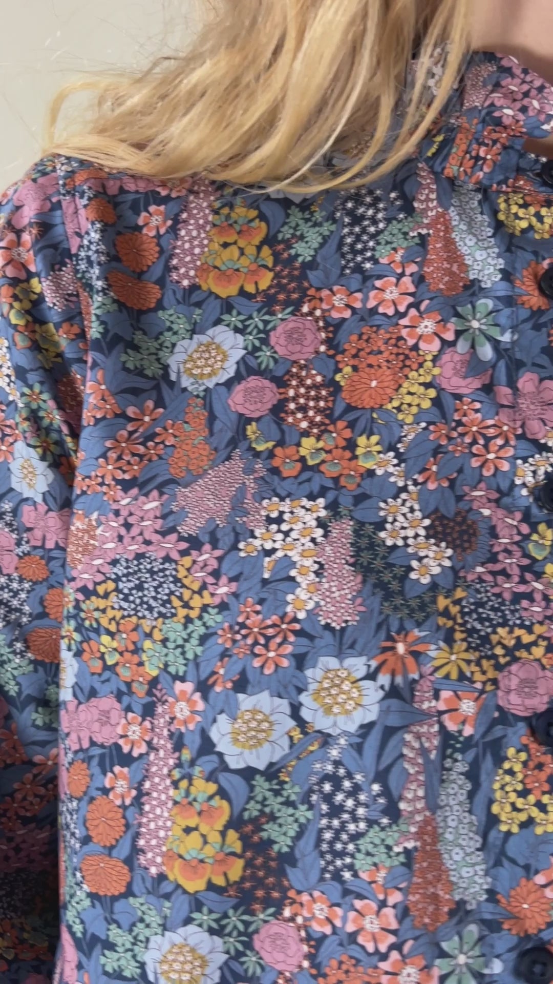Woman wearing long sleeved flower patterned shirt and trousers