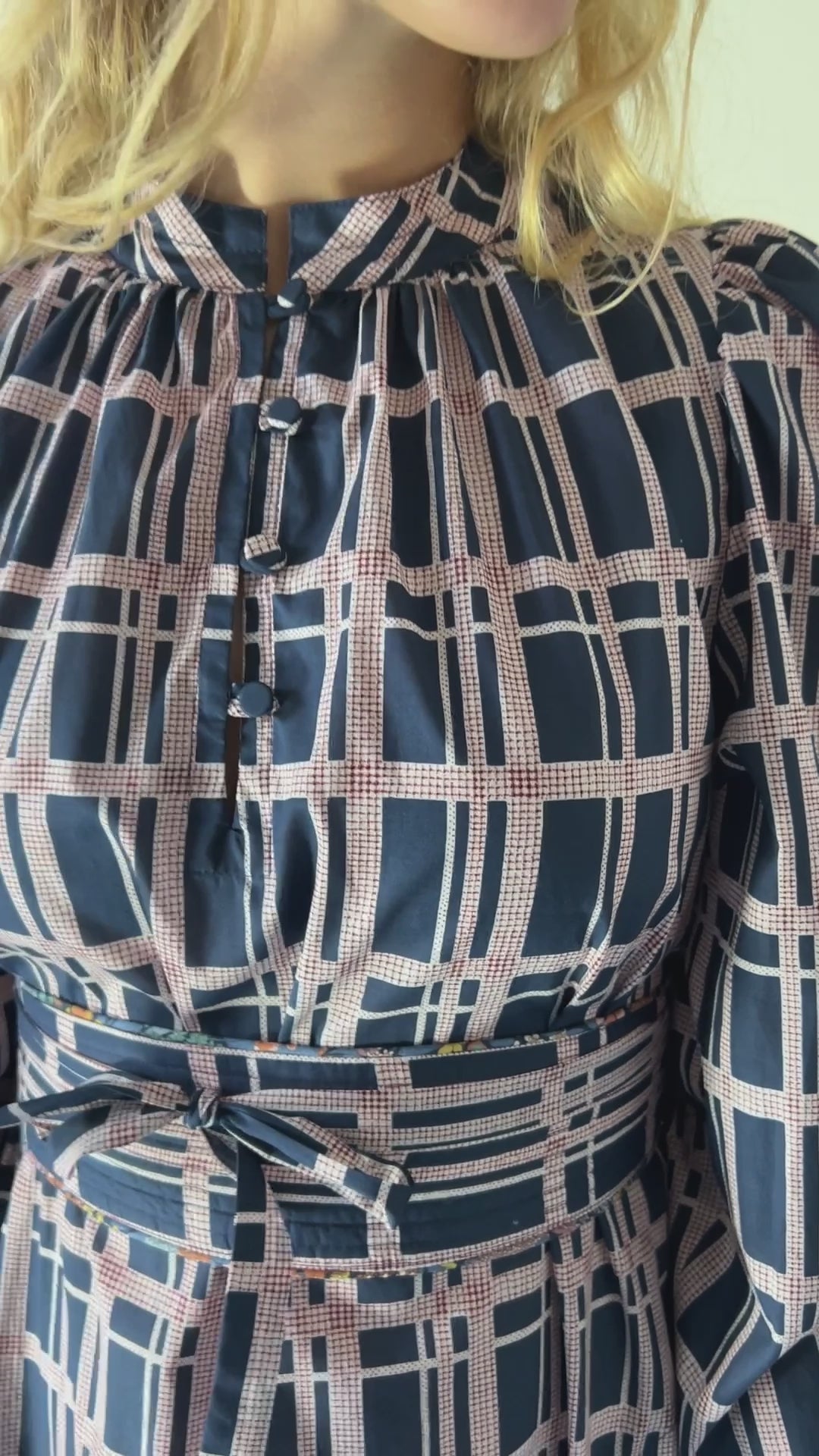 Woman in long Liberty cotton dress with pink and blue check print, long puffed sleeves and belt