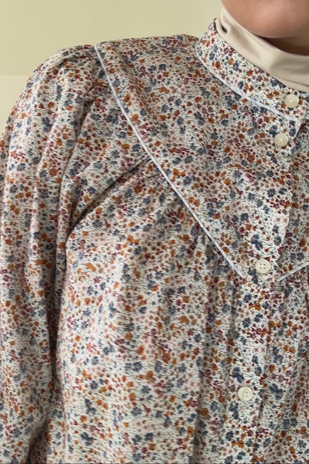 Woman in multi-colored small floral print shirt with puff sleeves and buttons