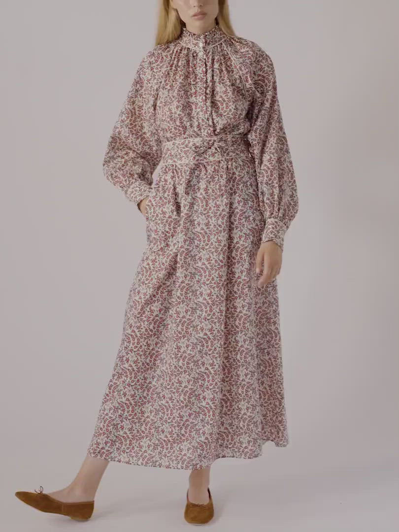 Woman in long dress with red flower pattern, puffed long sleeves and red shoes