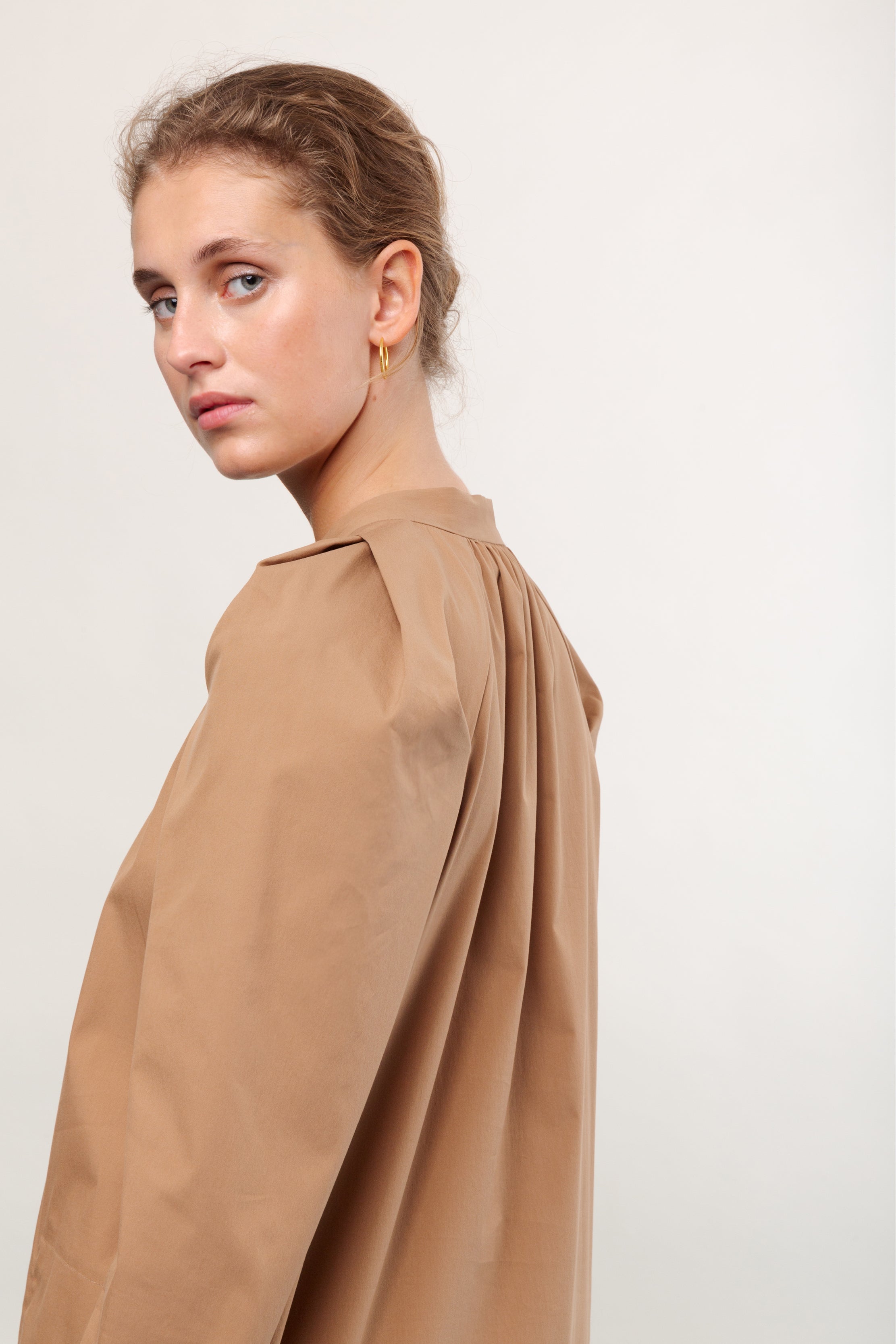 Woman in brown shirt dress with long sleeves