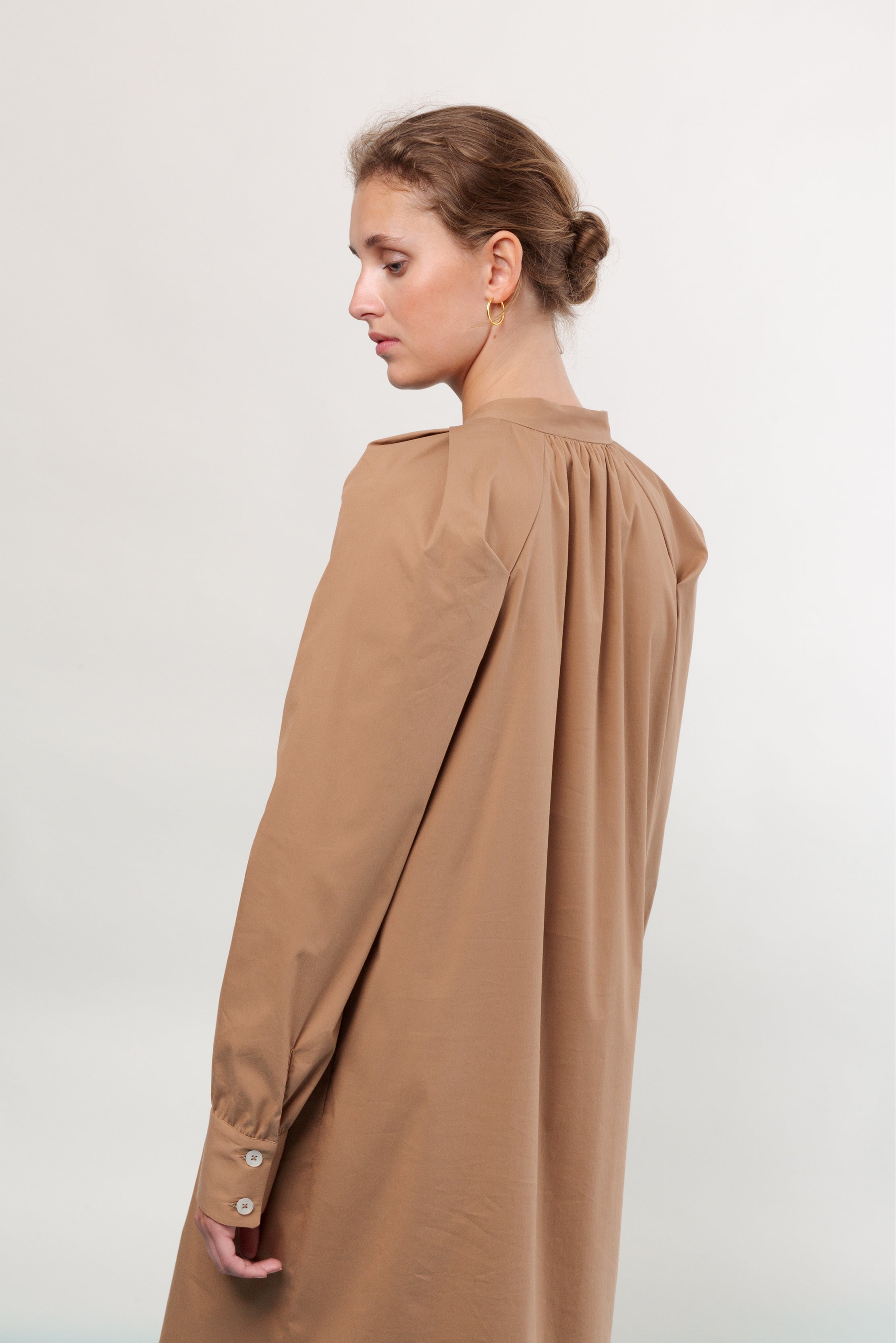 Woman in brown shirt dress with long sleeves