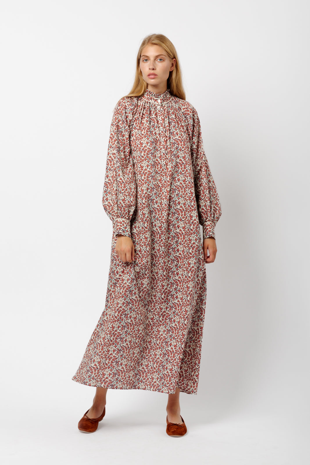 Woman in long dress with red flower pattern, puffed long sleeves and red shoes