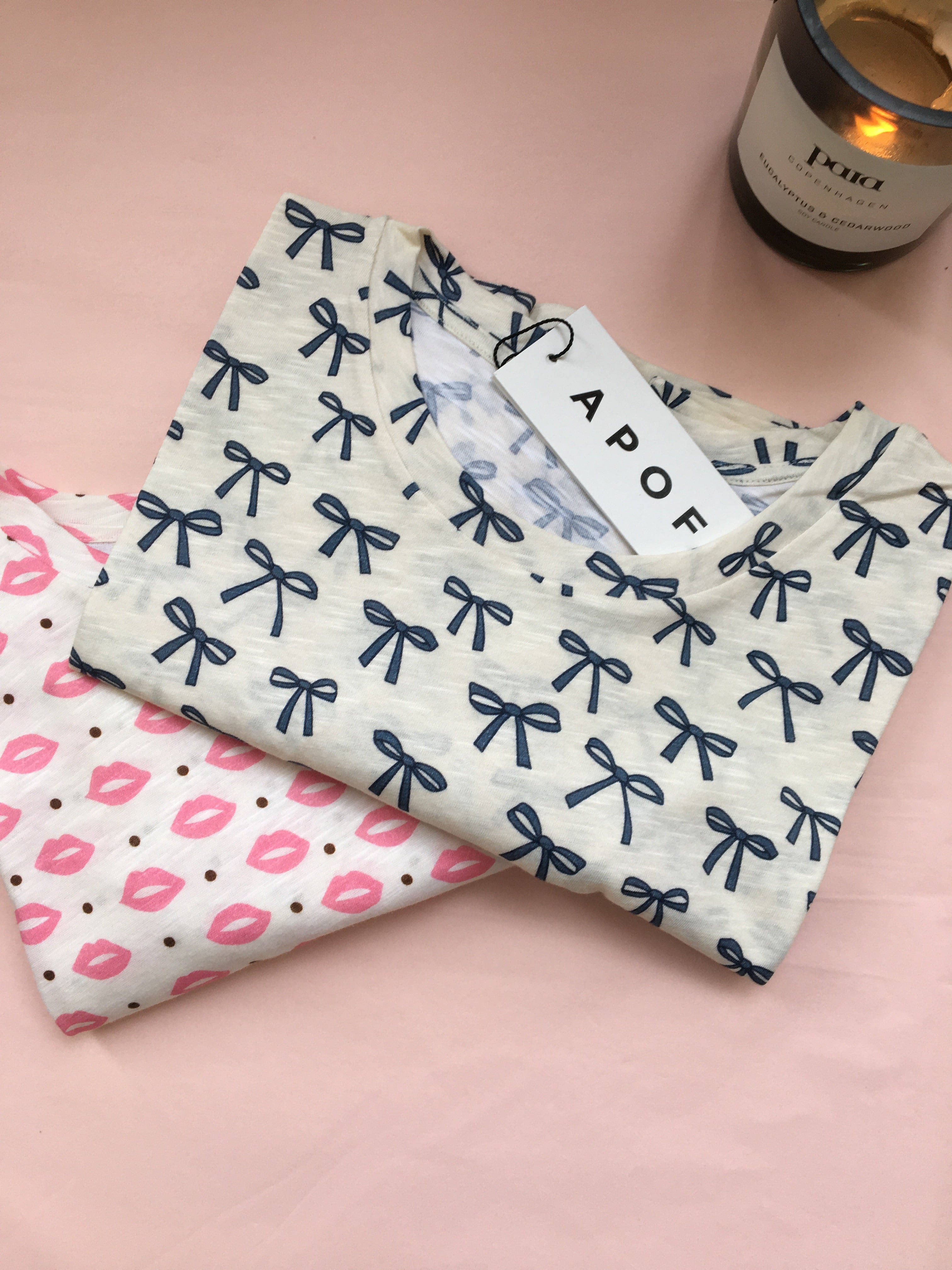Two folded women's t-shirts and Apof tag