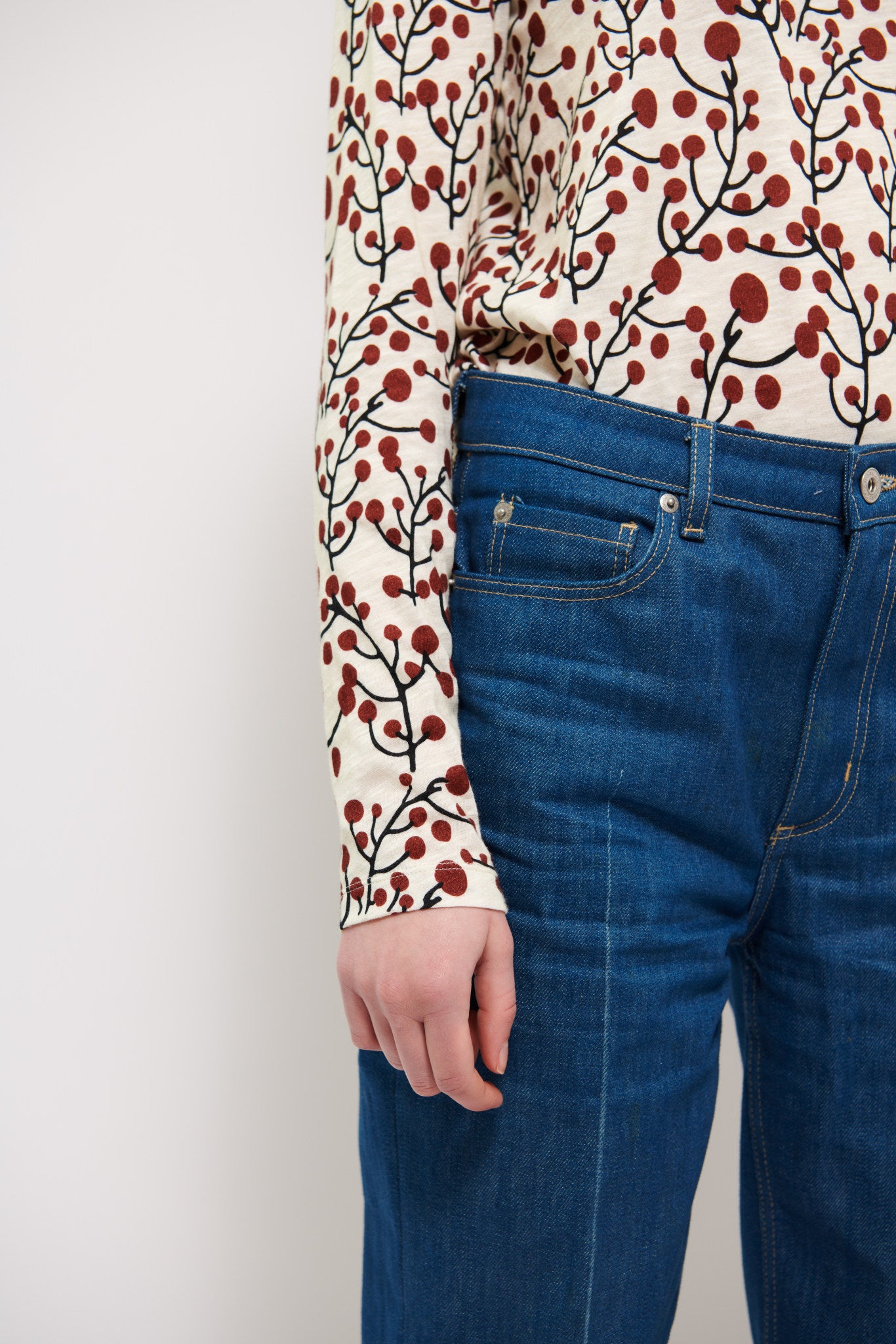 Dam långärmad vit t-shirt med bärmönster och blå byxor