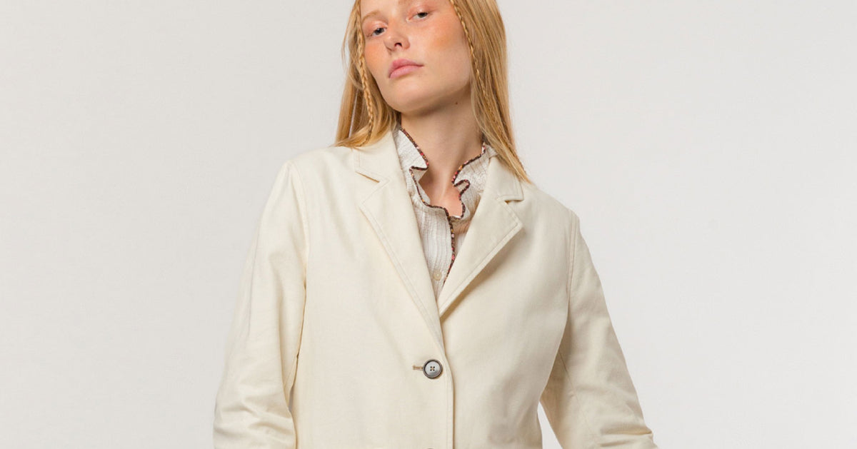 Woman in creme colored canvaz blazer with buttons and pockets