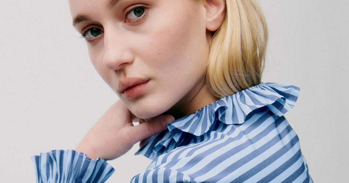 Woman in blue and white striped shirt with frills