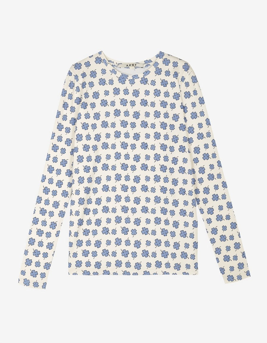 En langærmet rundhalset t-shirt til kvinder med et blåt blomsterprint over hele stoffet i cremefarve, vist fladt mod en lysegrå baggrund.