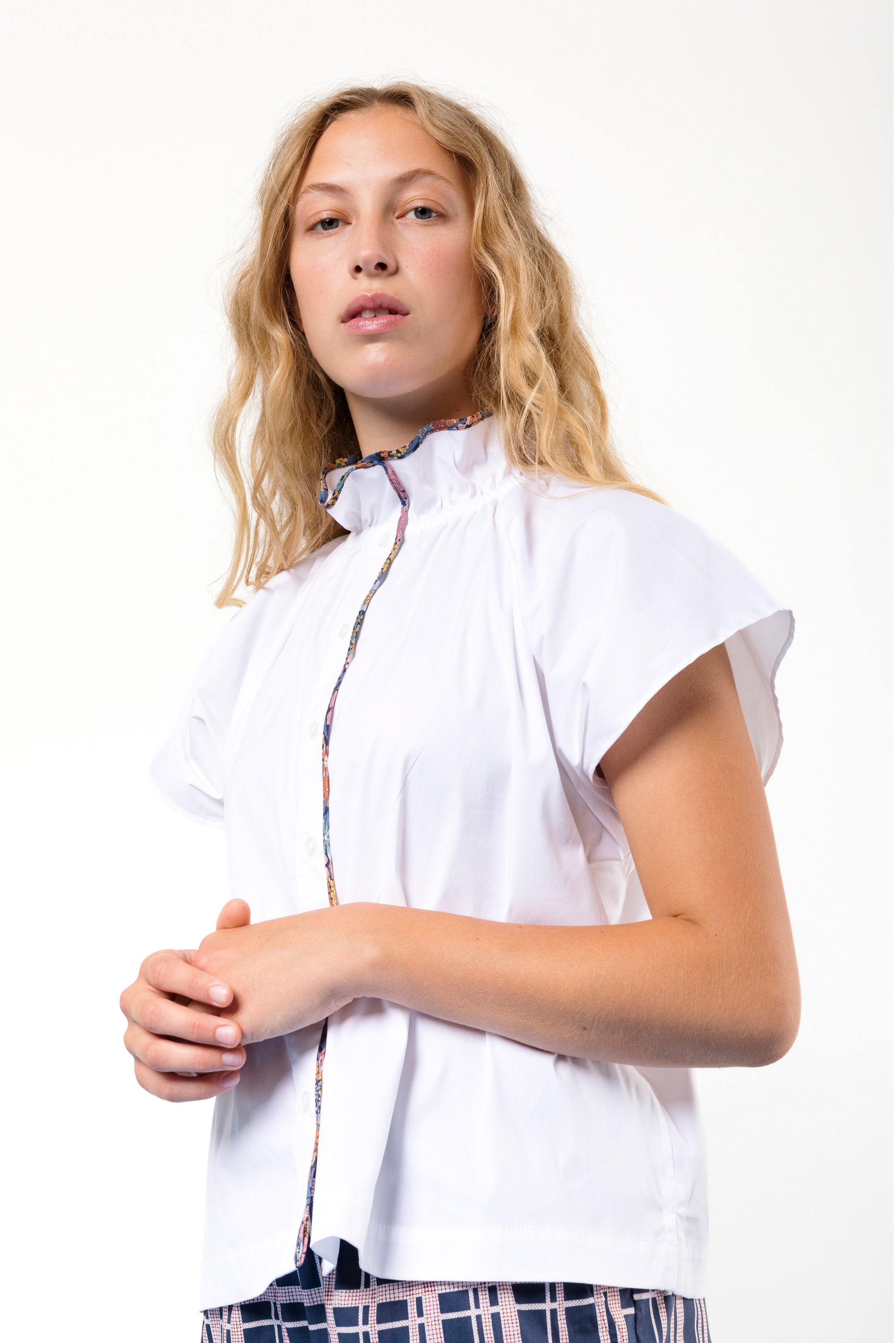 Woman in white blouse with short sleeves and frilled collar