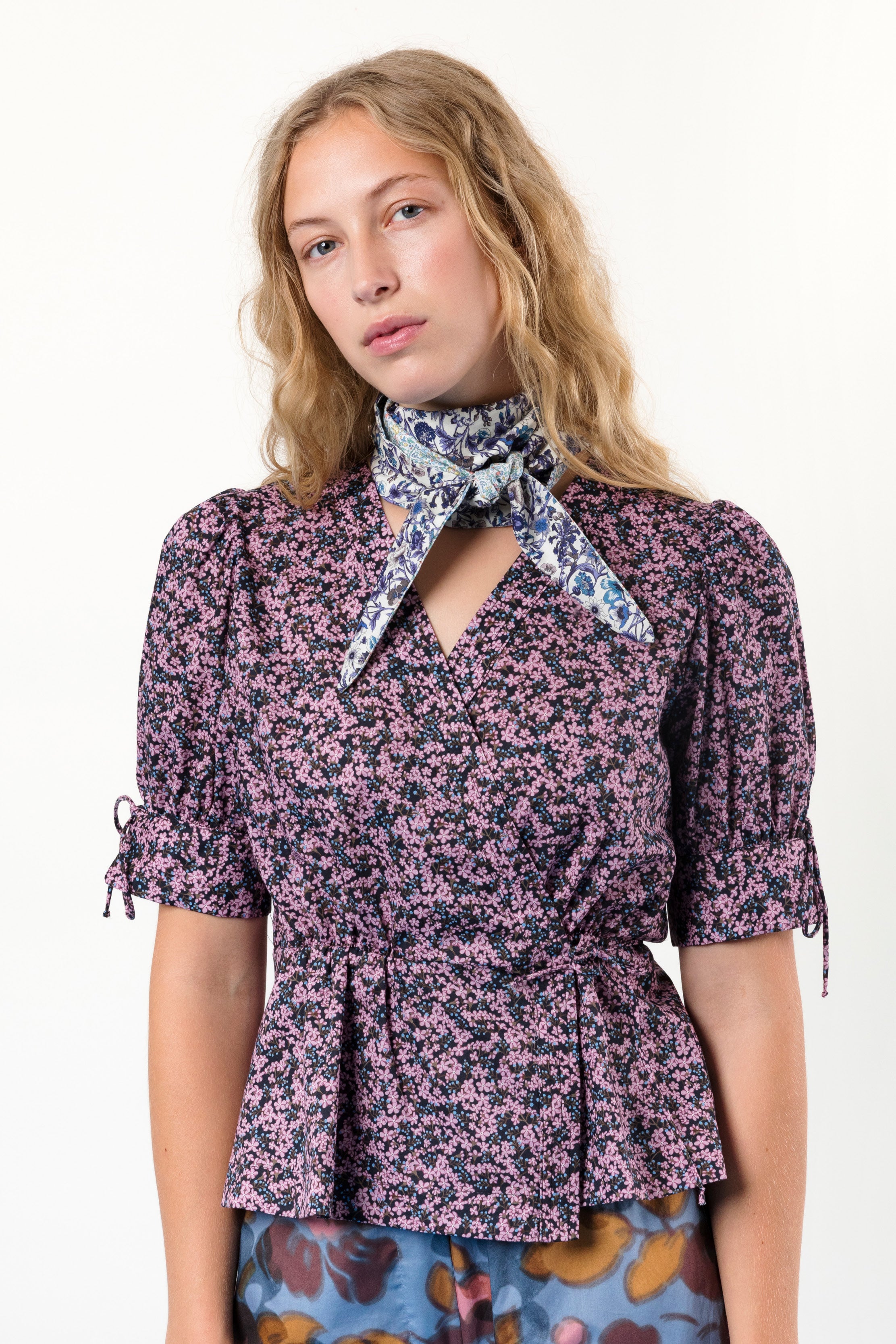 Woman in short sleeved wrap blouse with purple flower pattern