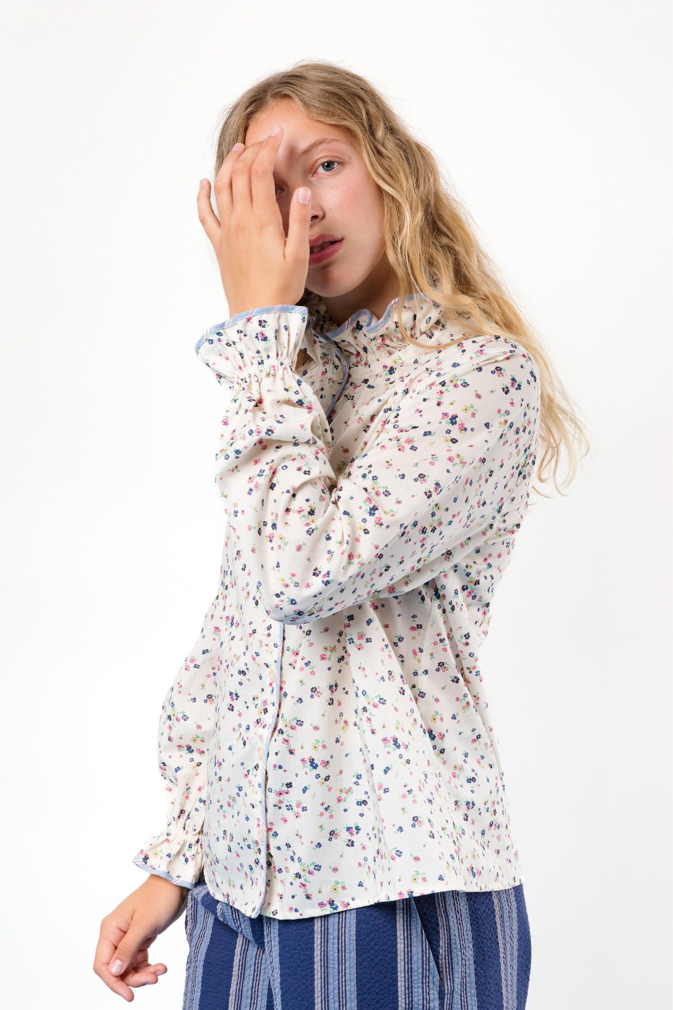 Woman in long sleeved shirt with frills and flower pattern