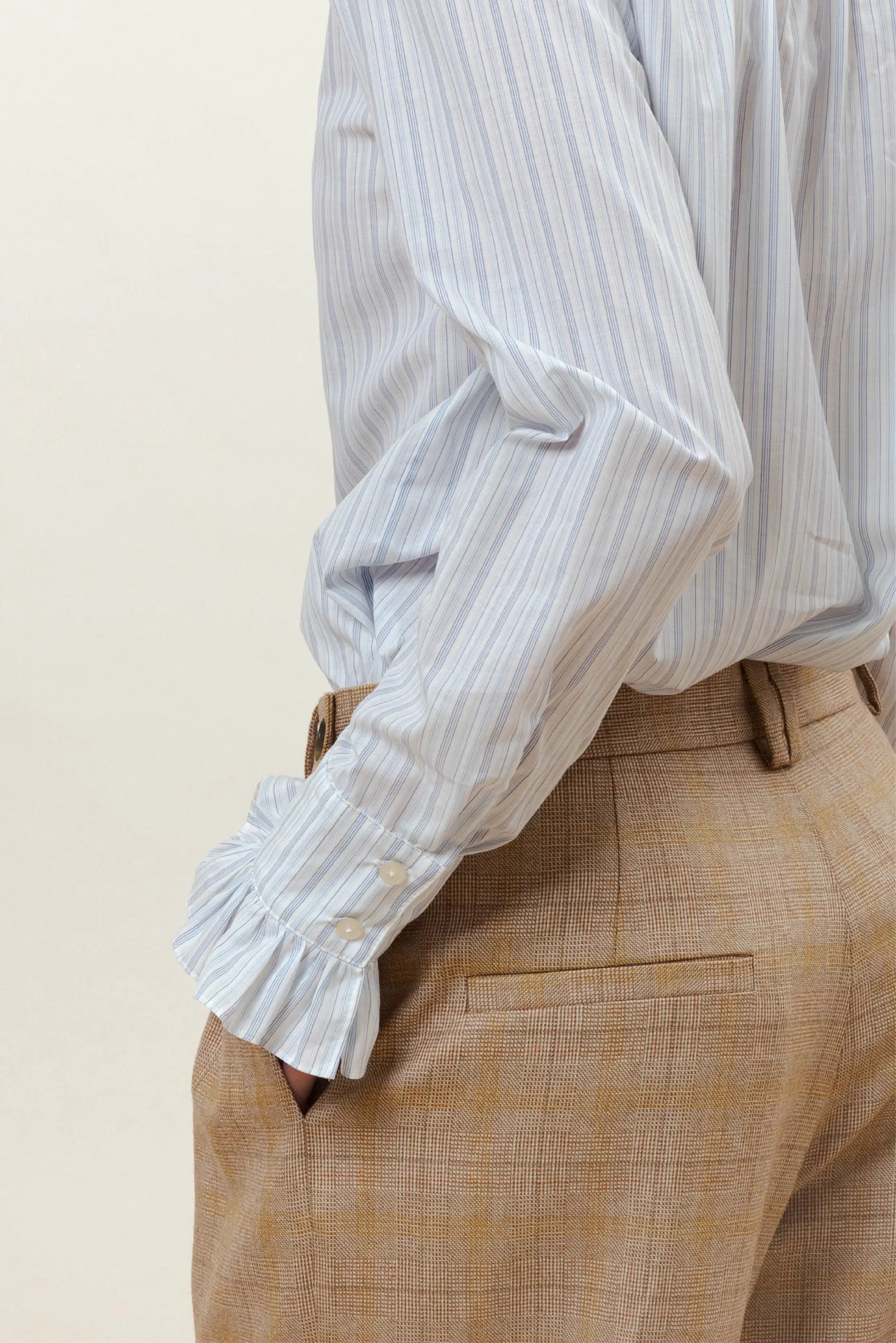 Beige checked trousers and blue striped shirt with ruffled cuffs