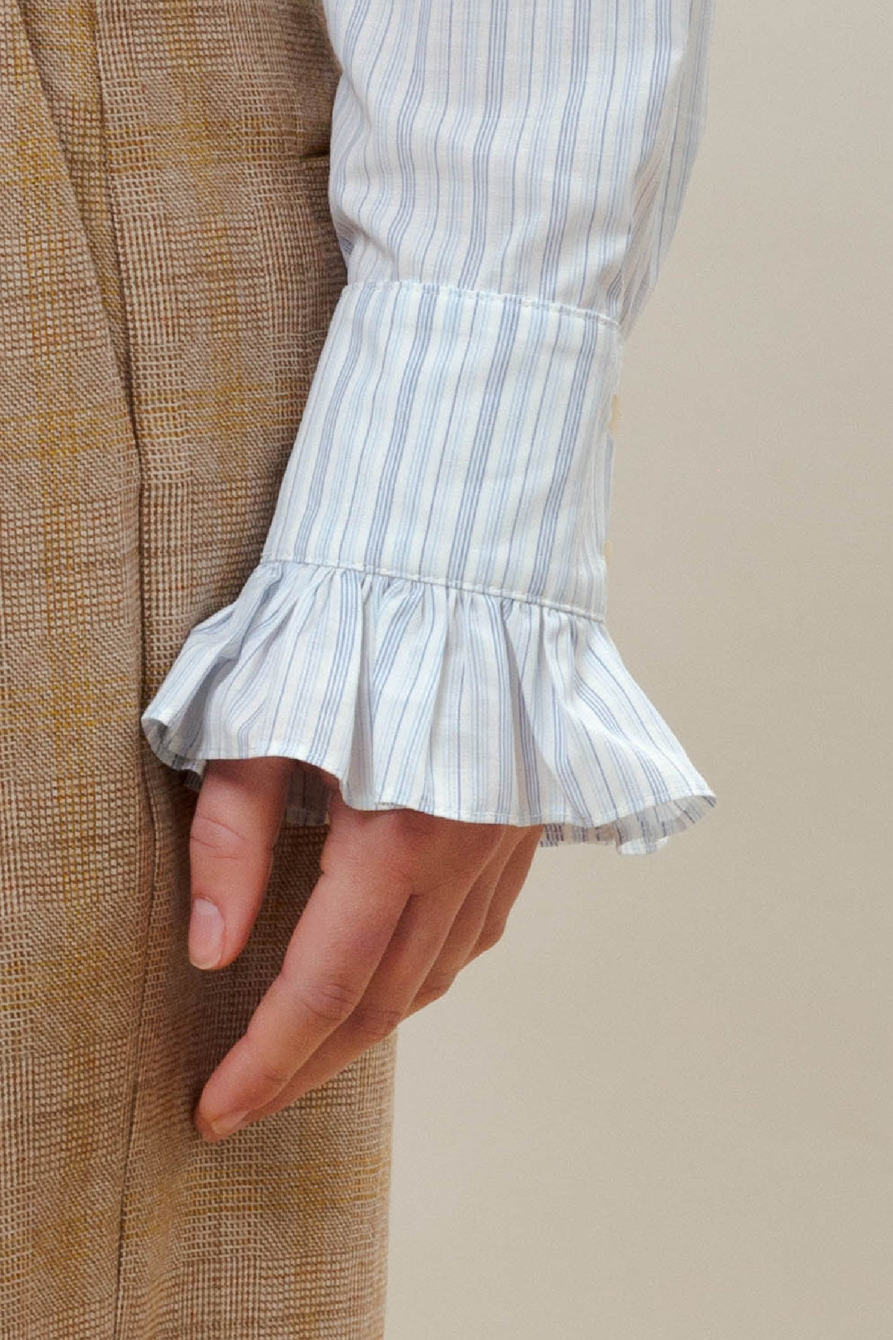 Beige checked trousers and blue striped shirt with ruffled cuffs