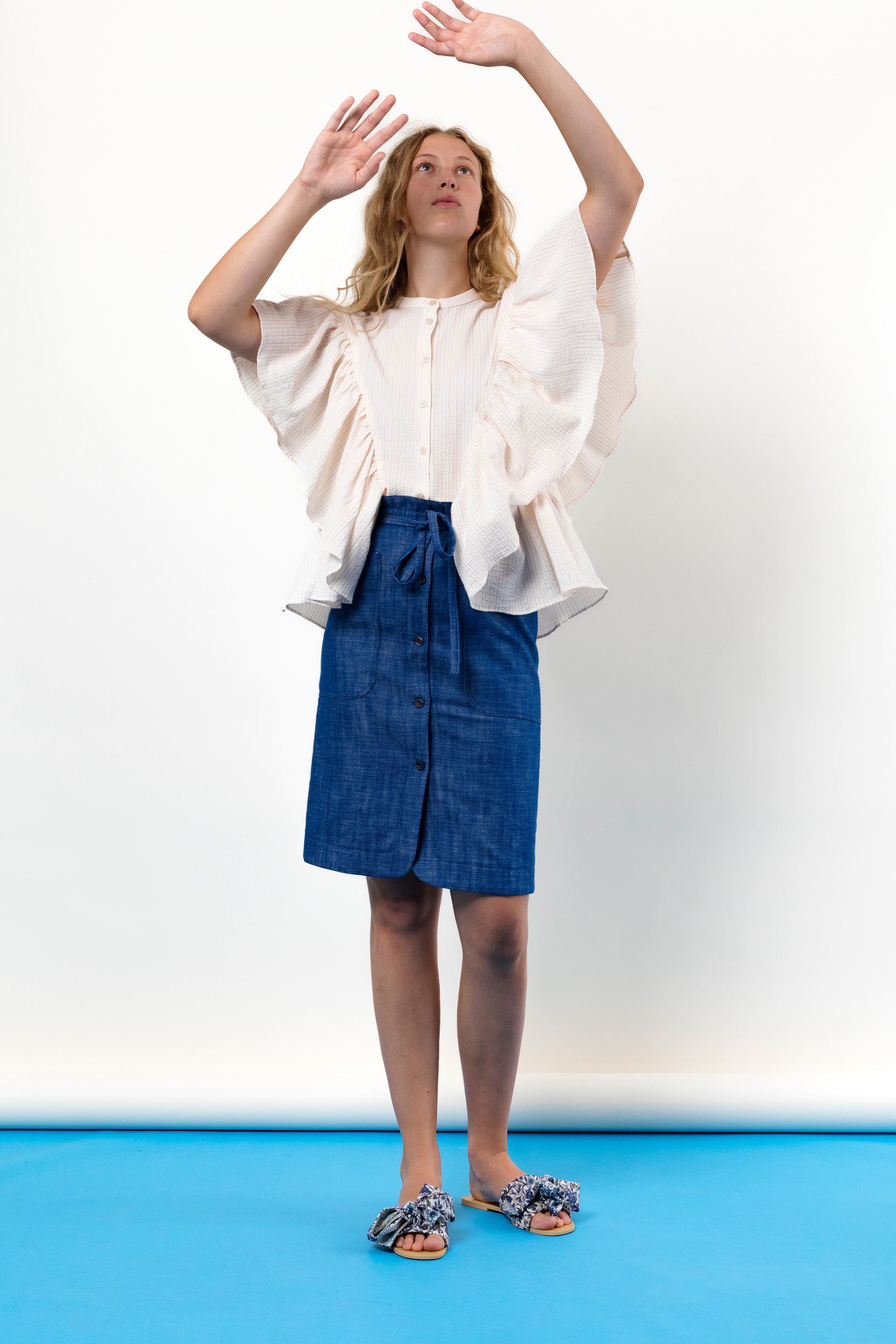 Woman in pink striped shirt with frills and skirt