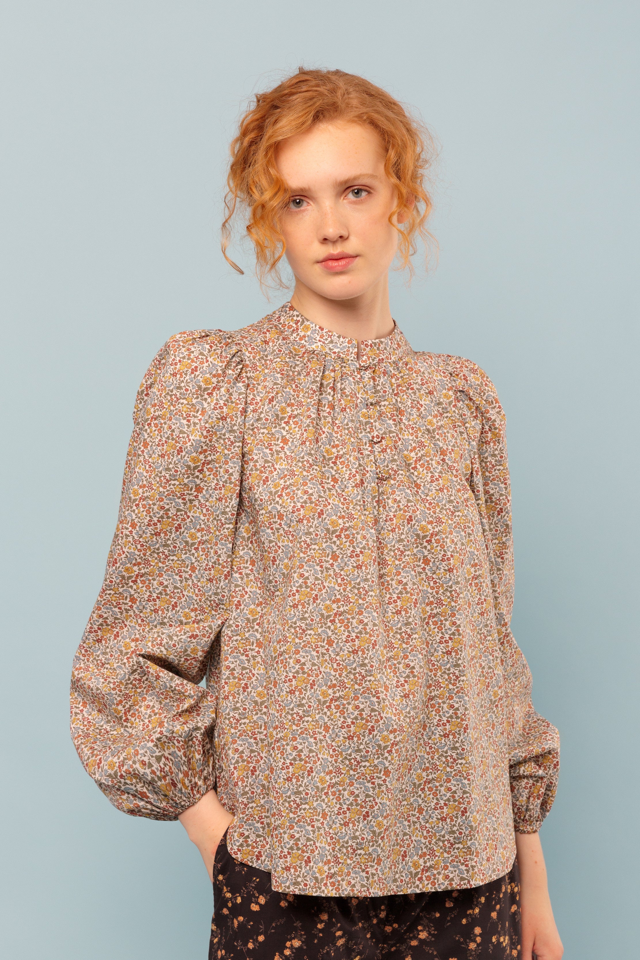 Woman in long sleeved flower patterned blouse